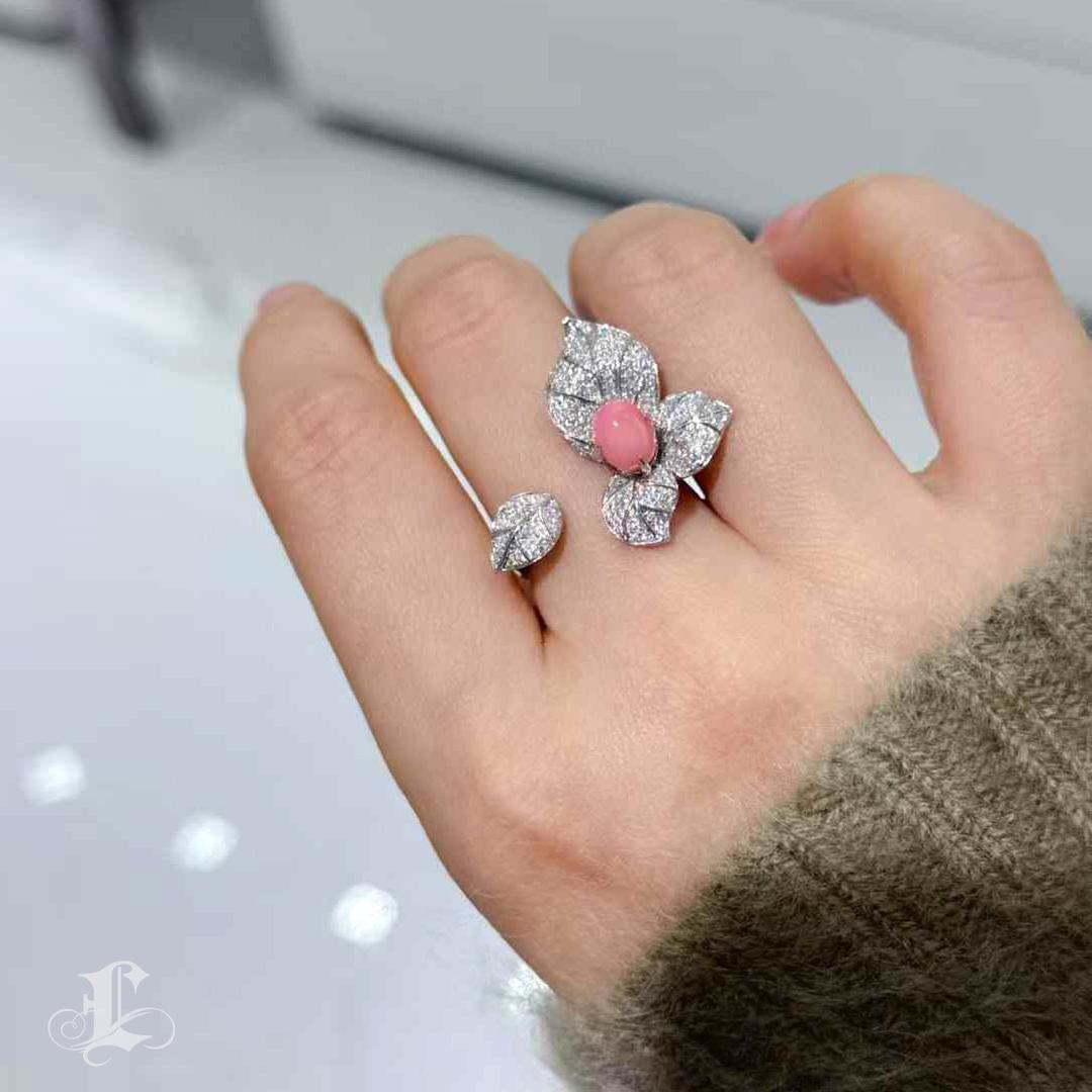 Come se fosse stato colto a metà da una brezza, questo poetico anello aperto evoca un momento di dolce eleganza. Al centro si trova una perla conchiglia naturale da 1,58 carati in un radioso colore rosa fenicottero, che brilla delicatamente con un