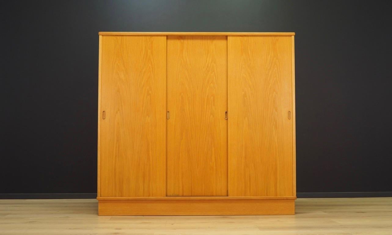Amazing wardrobe from the 1960s-1970s, Minimalist form - Scandinavian design by Tage Falsig for Bækmarksbro Møbelfabrik. Finished with ash veneer. Behind the sliding doors the wardrobe has shelves, two drawers, and a clothes hanger. Preserved in