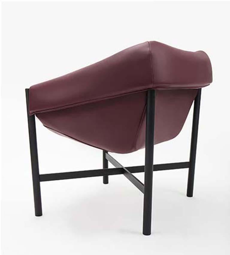 Ein mit Leder bezogener Sessel mit Metallgestell. Die unkonventionelle Art und Weise, wie der Sitz am Rohrrahmen befestigt ist, ist in allen Details sorgfältig durchdacht. Der opulente Sitz ist das Ergebnis einer Erkundung jenseits der Grenzen