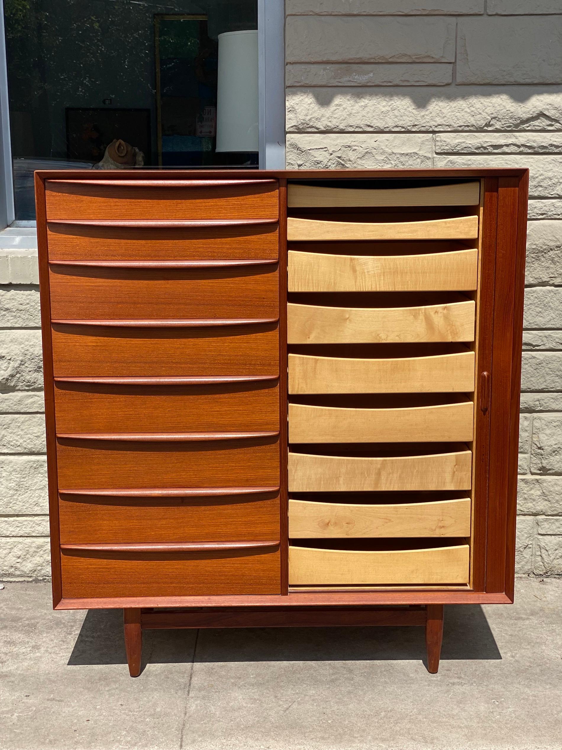 Beautiful mid-century modern teak gentleman's chest with tambour door by Falster features 17 drawers with 8 on the left hand and 9 on the right. This gentleman's chest or tall dresser is in great condition. 