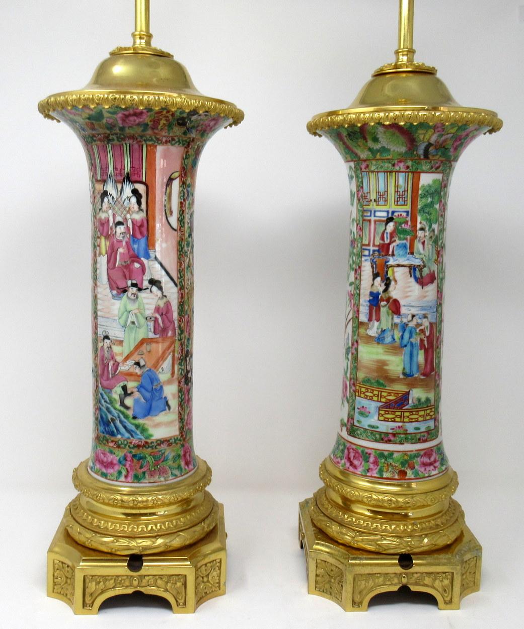 An exceptionally fine pair of Cantonese hand decorated porcelain oil lamps with ornate ormolu bases now converted to electric table lamps, of large proportions, mid-19th century. 

The main outer bodies of bulbous form with hand painted panels in