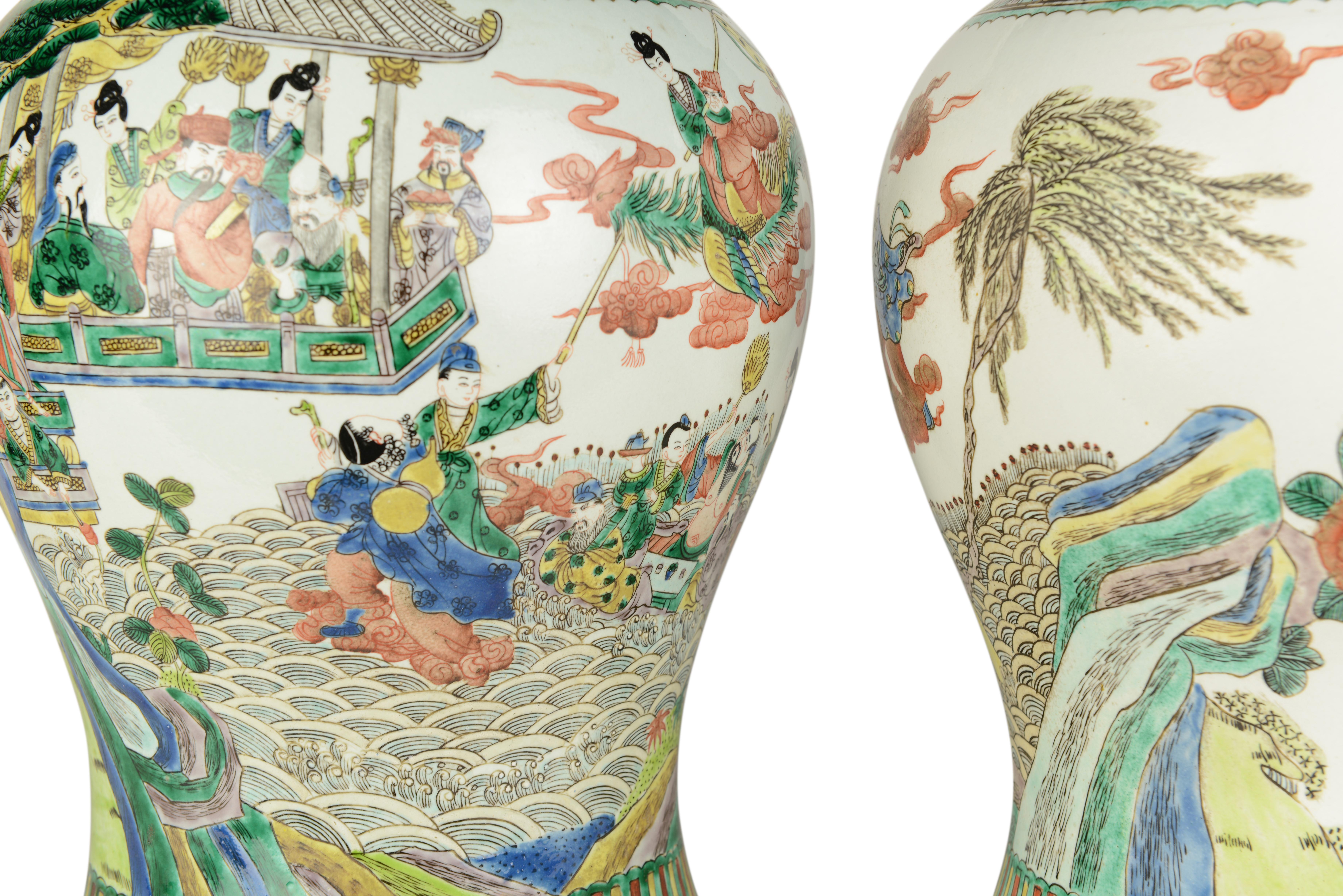 A fine pair of 20th century Chinese famille verte baluster vases, decorated with characters amongst trees and foliage and rocky outcrops with furthers stylised foliate detailing, predominantly in tones of green on a white background, now mounted as