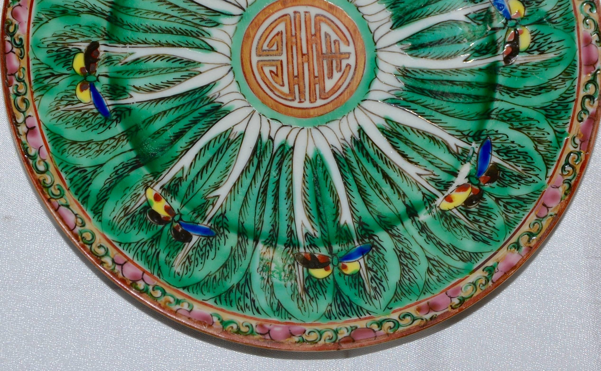 This porcelain plate has been hand painted with cabbage leaves and butterfly's floating about. The edge has a swirled border on the edge. The plate is not marked.