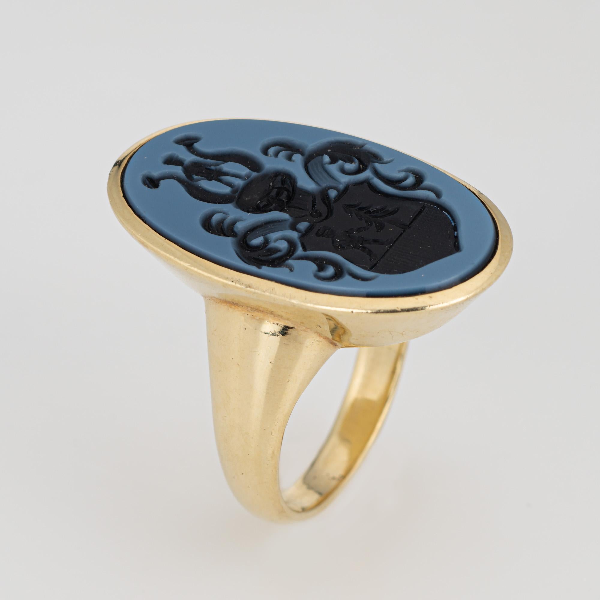 Stylish vintage family crest signet ring crafted in 14 karat yellow gold. 

Blue agate measures 24mm x 14mm. The agate is in very good condition and free of cracks or chips. 

Blue agate intaglio features an elaborate family crest. The long oval