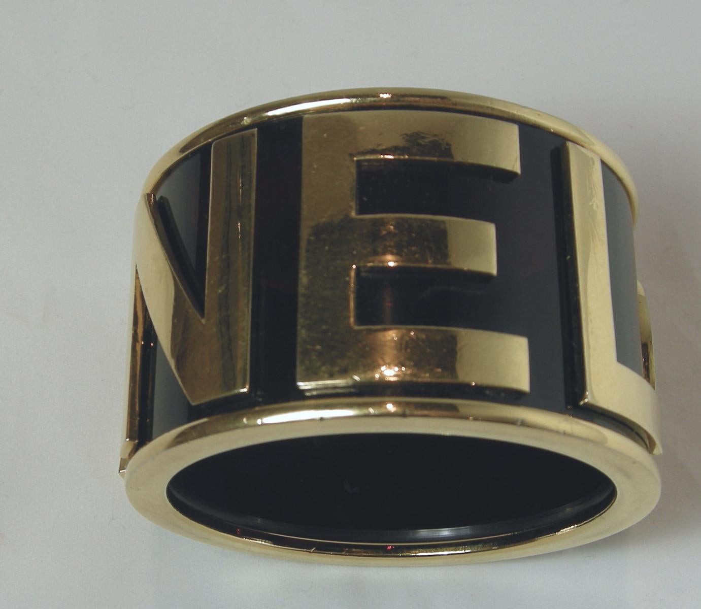 This is one of the most popular of all the Chanel cuffs.  It has gold tone rims with the word “Chanel” in large letters going around the cuff against faux amber Gripoix glass.   It measures 8” on the inside and 2” high.  It is signed “Chanel” and is