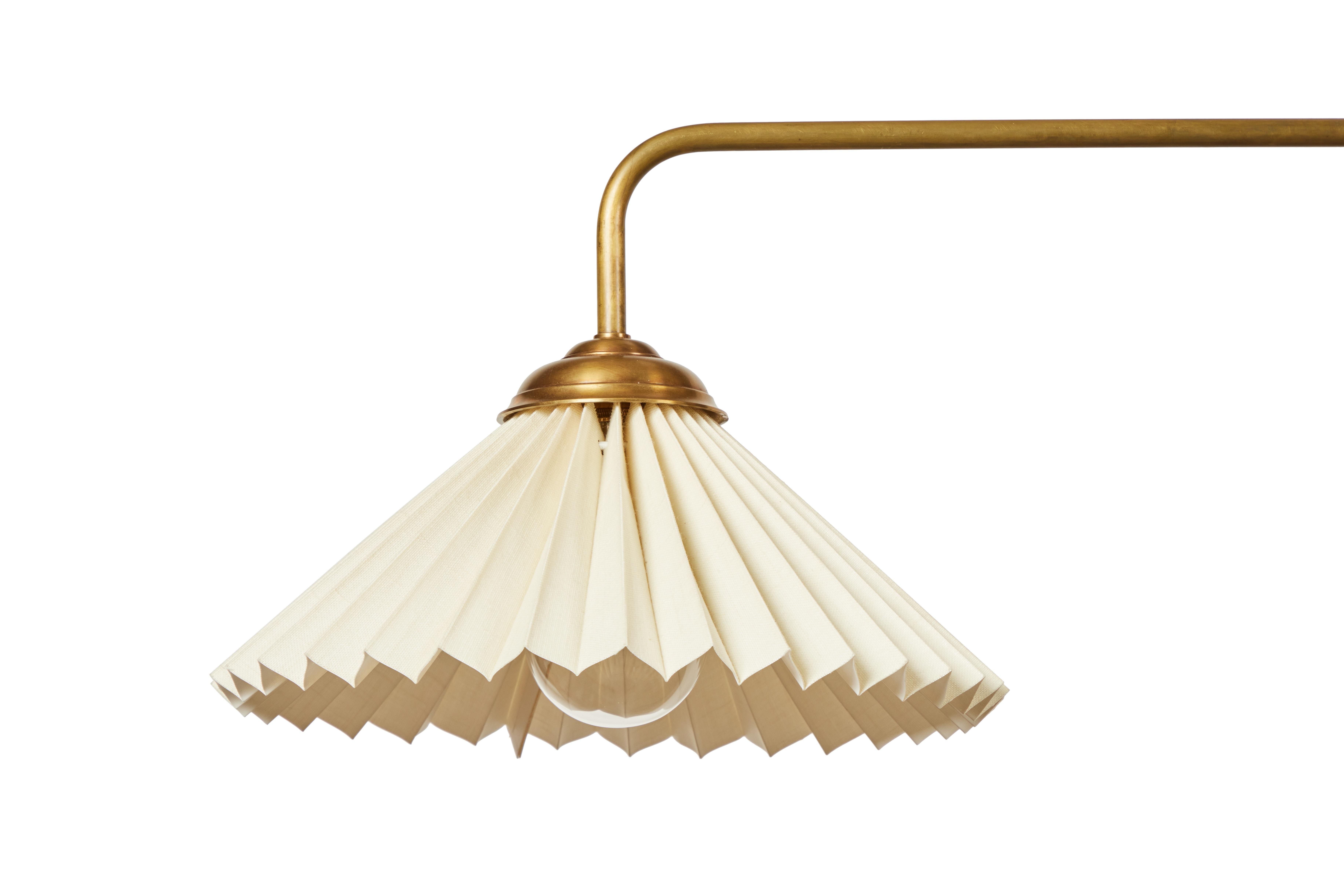 The Fan chandelier is a two light linear pendant in aged unlacquered brass. It features a cream linen pleated shade.

LEAD TIME: 10-15 weeks
 
DIMENSIONS: 28
