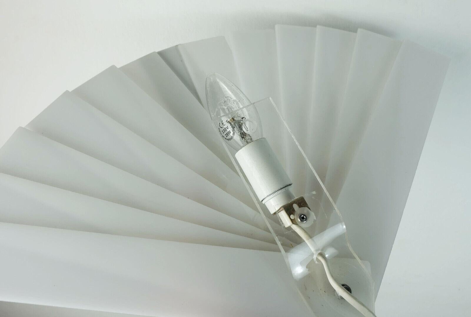 1980s fan-shaped sconce made of slightly flexible white acrylic. For direct connection to the wall without a switch. Holds one E14 bulb.

Dimensions in cm:
Width 49 cm, height 30 cm, depth 6 cm.

Dimensions in inches:
Width 19.29