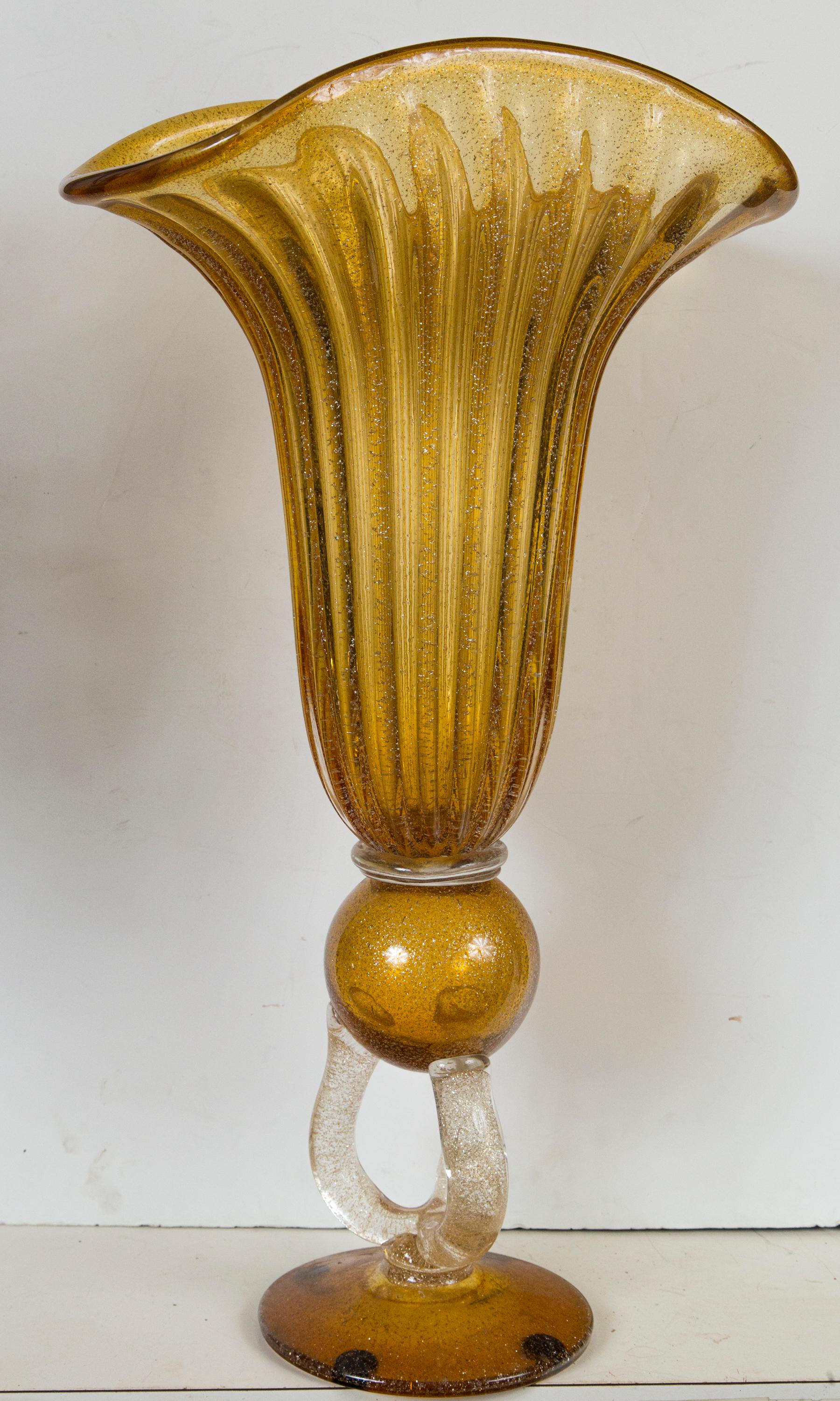 Yellow/amber and clear glass at the base, with flex of gold throughout. Ribbed flaring body, upon a ball, upon 3 clear glass supports, upon a round base 6.5 inches in diameter.