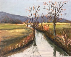 Paysage d'automne français d'un canal doublé d'arbres avec reflets et collines distances