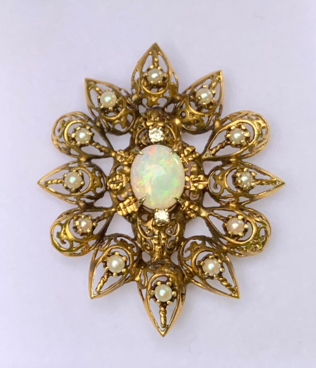Exquisite, antique estate, late Victorian, hand made fanciful filagree openwork opal, diamond and pearl brooch pendant is an elaborately detailed oval starburst-type shape and is constructed out of 14 karat yellow gold which has a natural antique