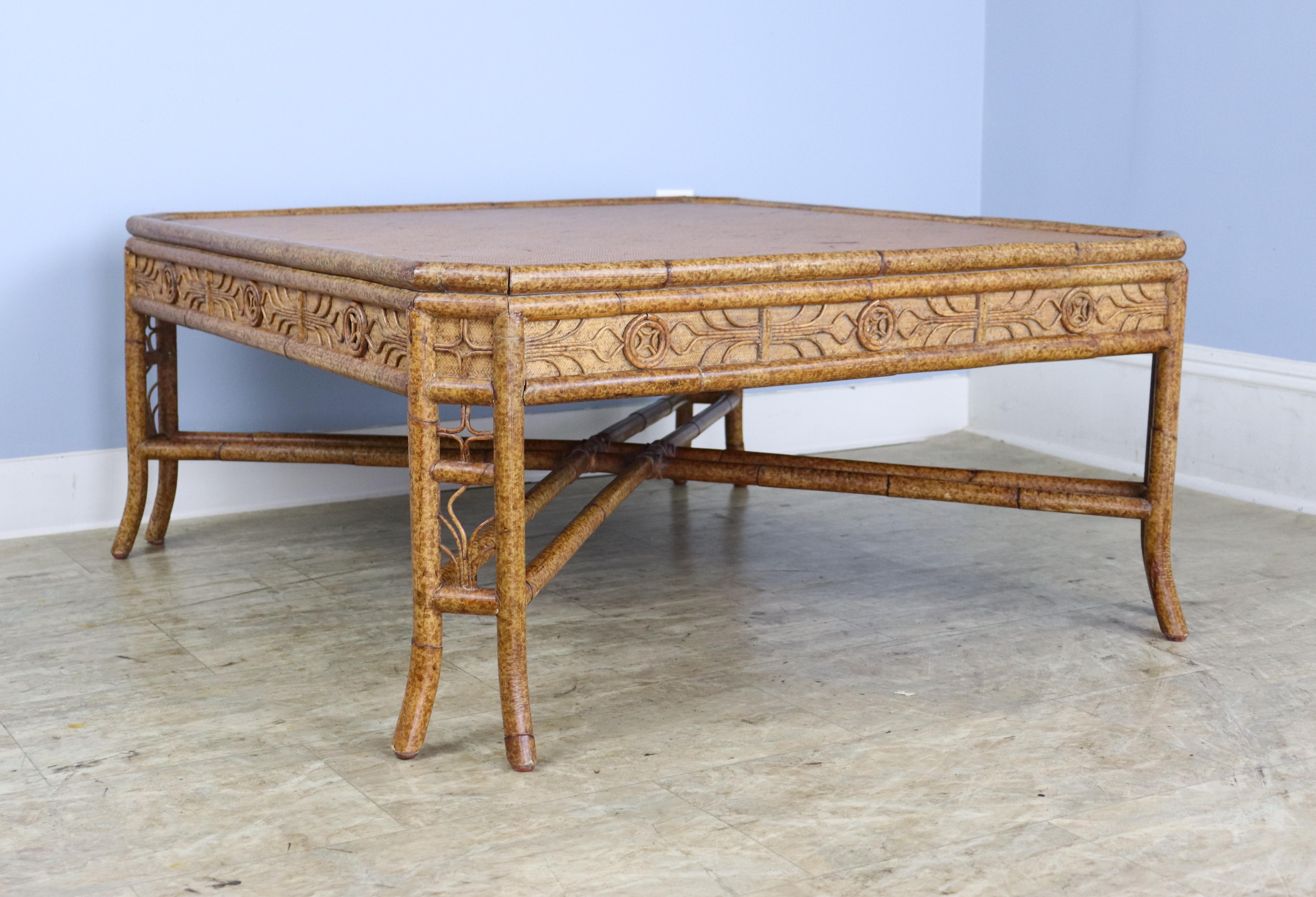 A whimsical square bamboo coffee table, decorated with lots of good bamboo details all the way around the top.  The woven rattan top has som areas of wear, shown.  Otherwise, the piece is quite sturdy and in good condition.