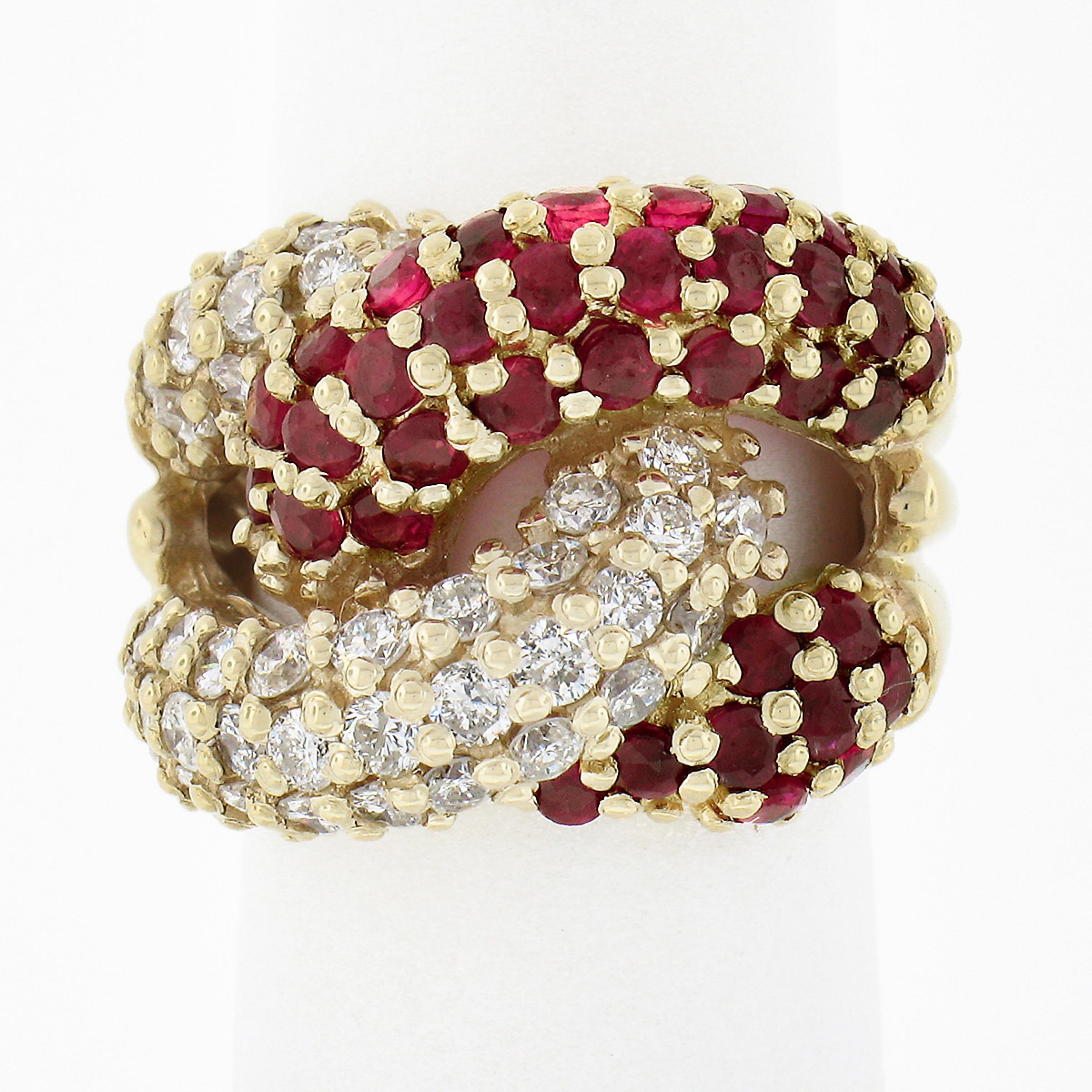 This gorgeous wide band ring was crafted in solid 14k yellow gold and features a puffed and interlocking loop design that is neatly prong set with round brilliant cut diamonds and rubies throughout. The fine rubies are set on one loop showing a deep