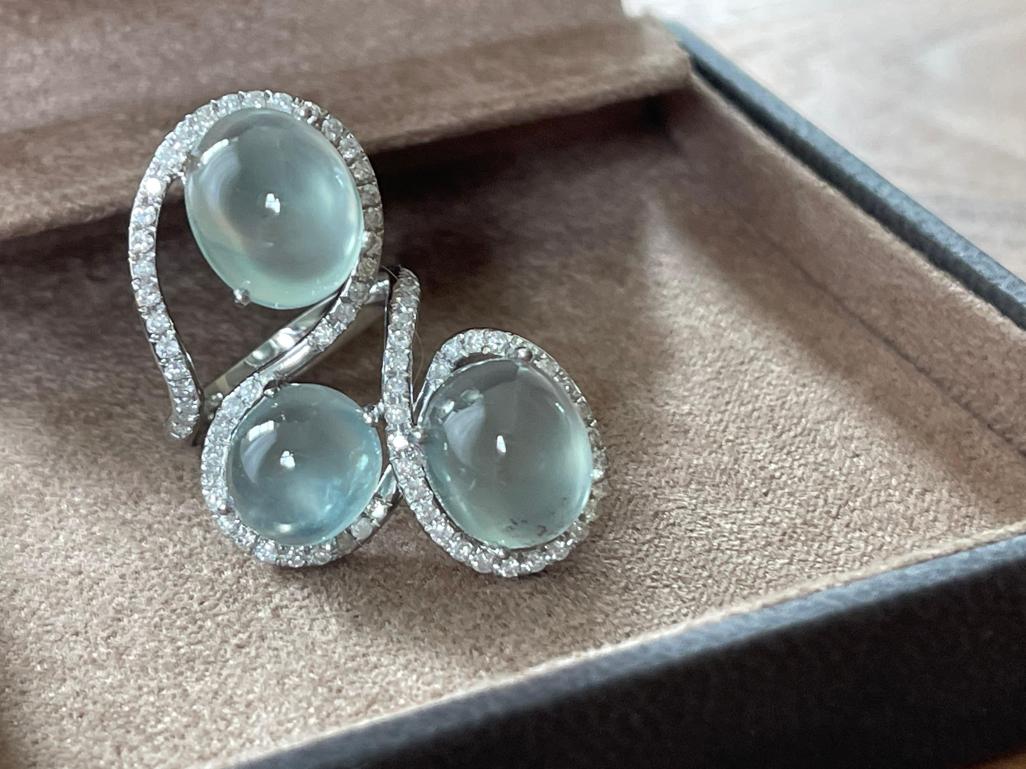 Fancy 18 K white Gold Ring featuring 3 Prehnite Cabochons weighing 22.18 ct and 75 brillinat cut Diamonds weighing 0.86 ct. 
The ring is currently size 15/55 ( american ring size 7 1/2) but can easily be resized. 
Masterfully handcrafted piece!