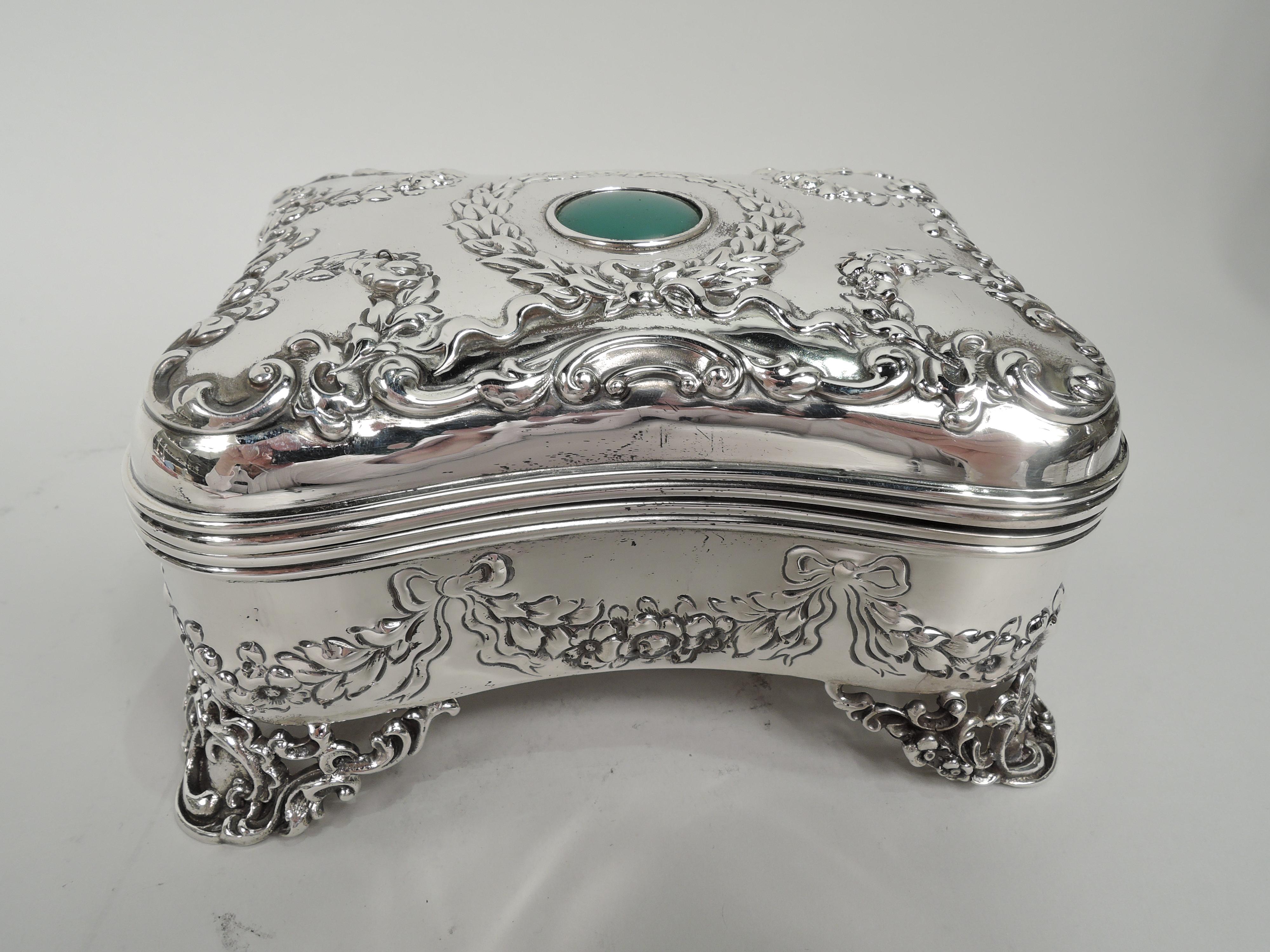 Turn-of-the-century Victorian Regency sterling silver jewelry box. Made by Mauser in New York. Rectangular and concave with curved corners and hinged cover. Chased ornament including garlands and scrollwork. On cover top is inset green hardstone