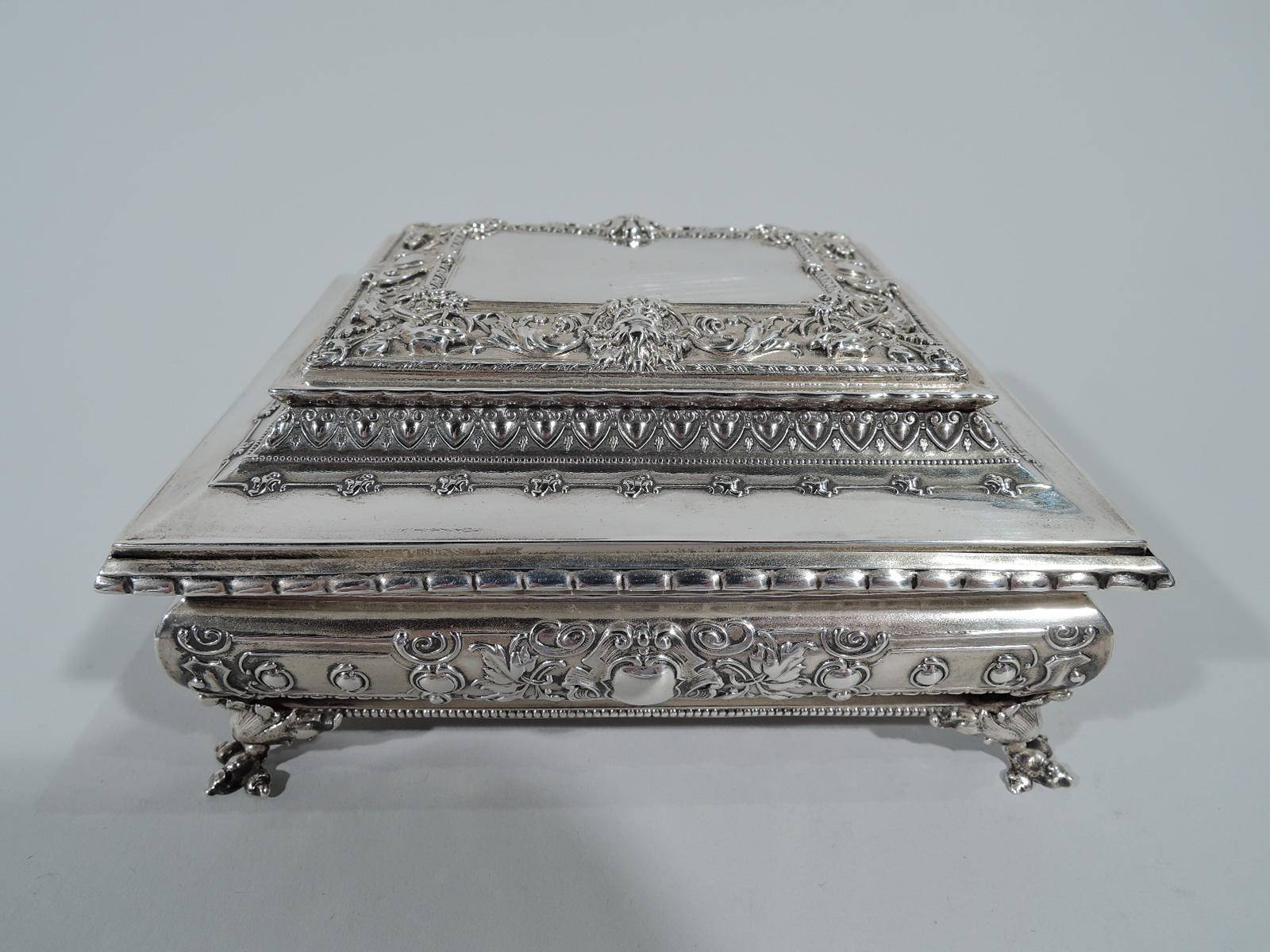 Fancy sterling silver keepsake box. Made by Kerr in Newark, circa 1890. Rectangular with bellied sides. Cover stepped, inset, and hinged. Four corner leaf-mounted talon supports. Classical ornament with leaf-and-dart, beading, masks, and foliate