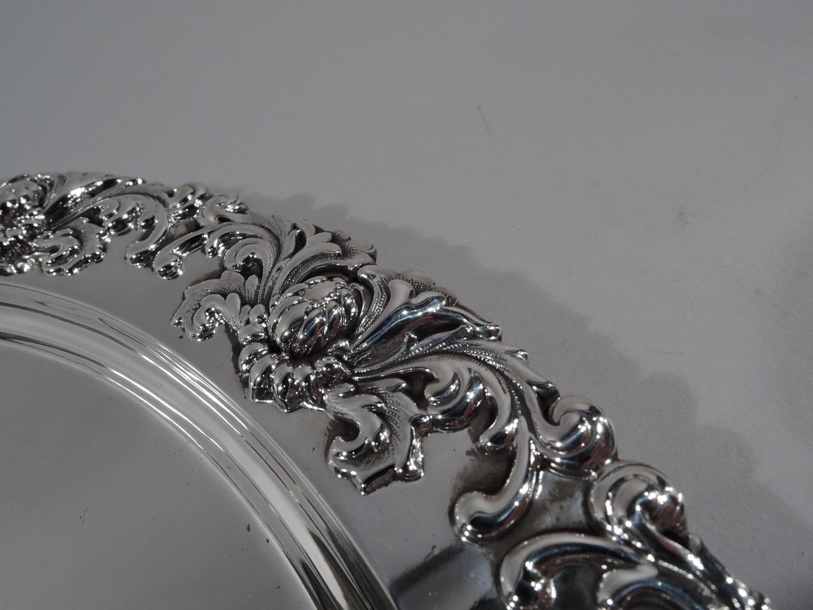 Chrysanthemum sterling silver serving tray. Made by Tiffany & Co. in New York. Round with deep well. Flat and narrow shoulder with applied rim ornament comprising buds in leafing scrolls. Striking and tactile. Fully marked including pattern no. 5766