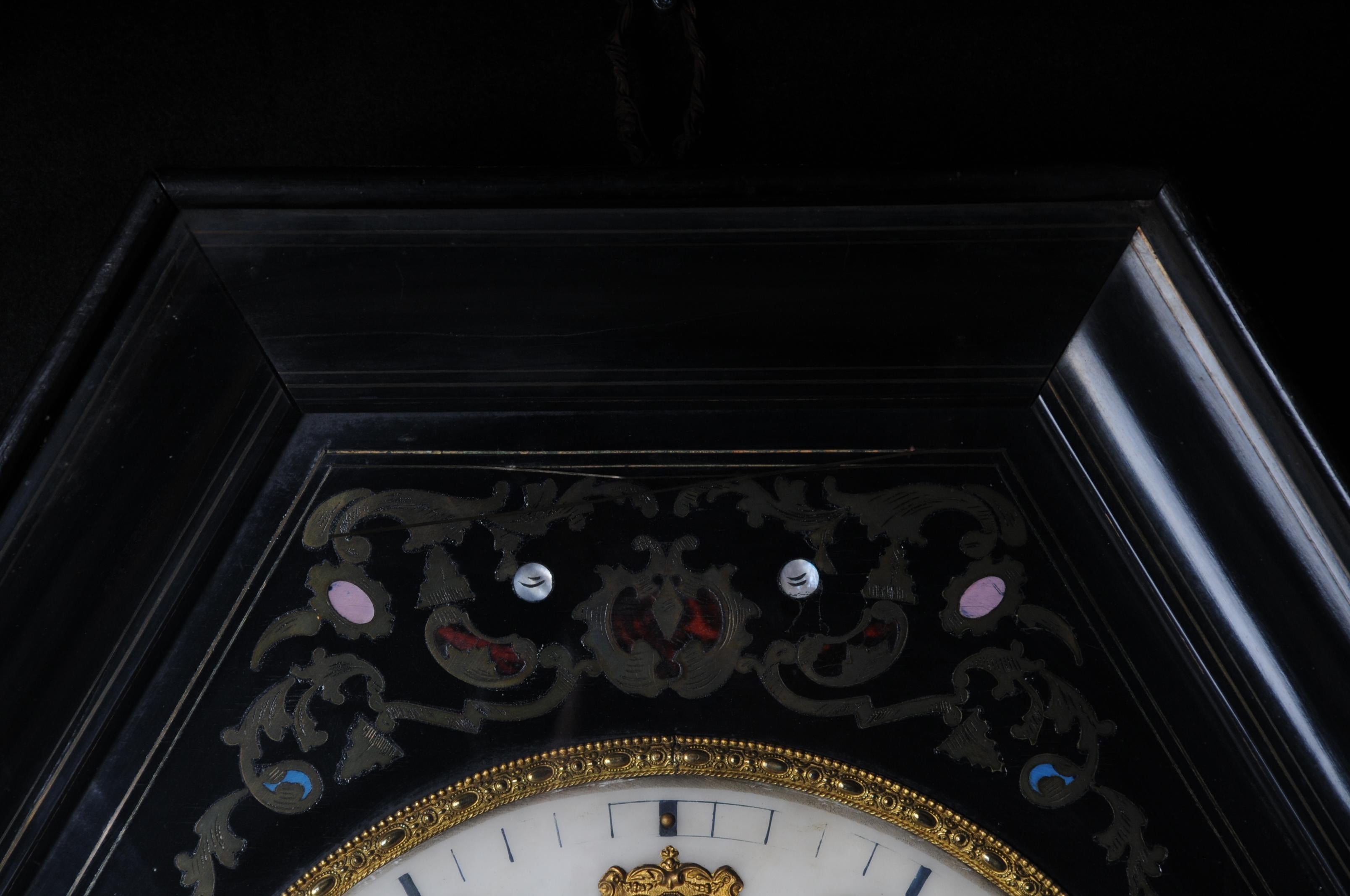 Fancy antique wall clock, circa 1850.

Octagonal-shaped and black-framed body with glazed door. White dial. Hand-inserted inlaid brass elements in Boulle technique. Movement must be checked for accuracy.

(R-59).