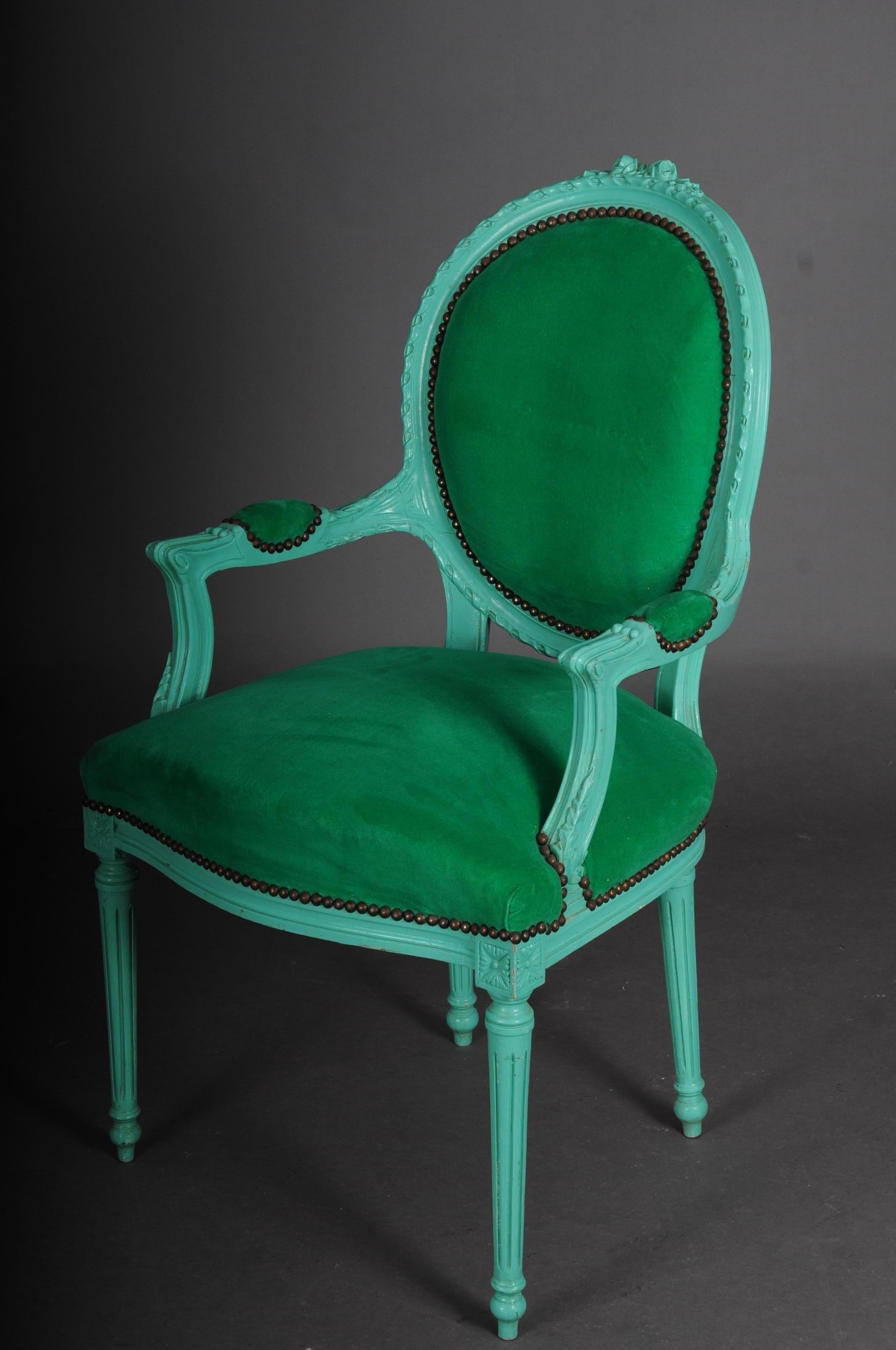 Fancy armchair in Louis XVI style, green

Solid wood, painted green. Curved and carved frame on fluted, tapered legs. Curly armrests. Straight supports with acanthus leaves on top. Rising armrests in oval backrest frames ending in carved rocaille