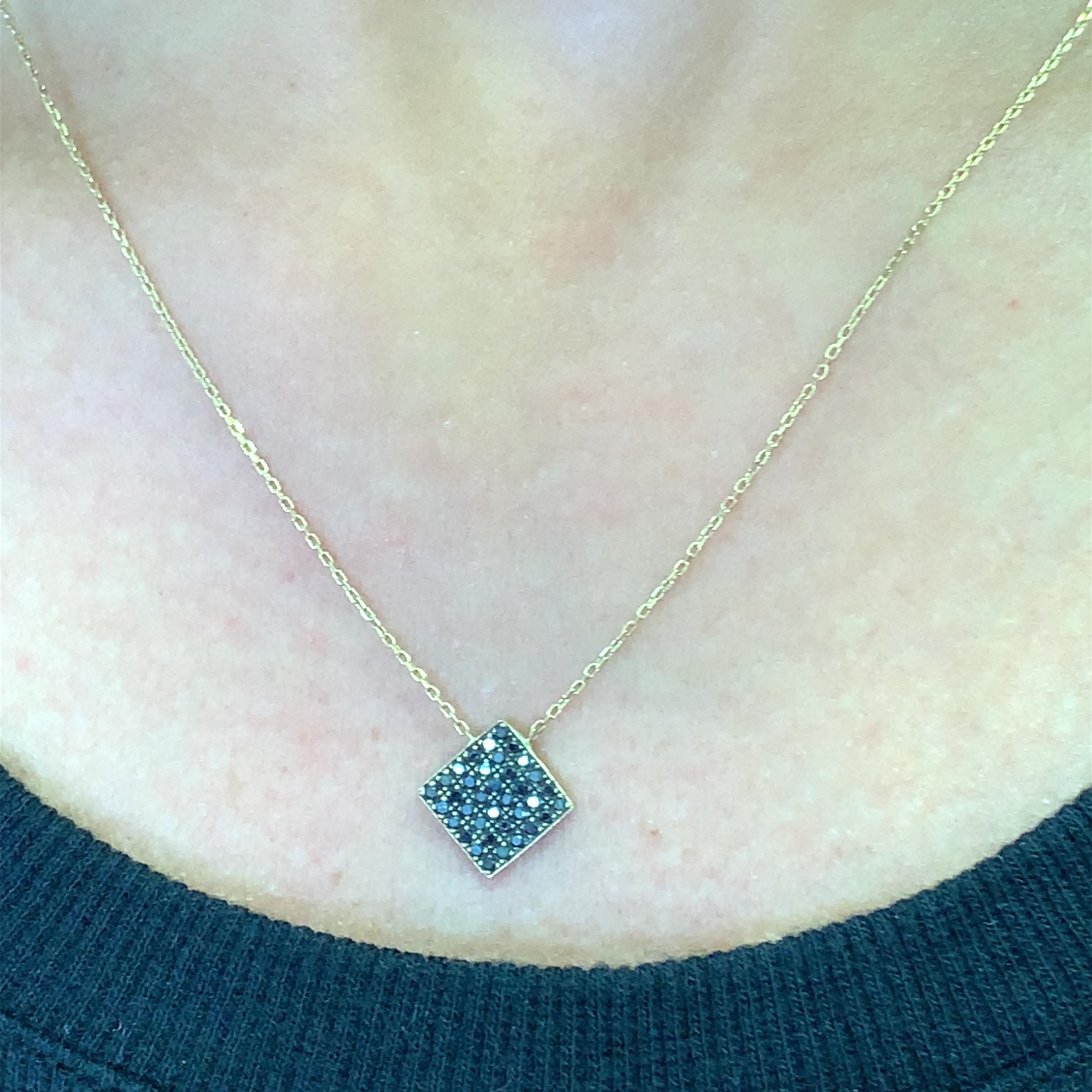 Elevate your style with this stunning yellow gold necklace featuring a square pendant adorned with a cluster of round cut fancy black diamonds. The brilliant cut diamonds create a captivating sparkle, offering a luxurious accent to any ensemble. A