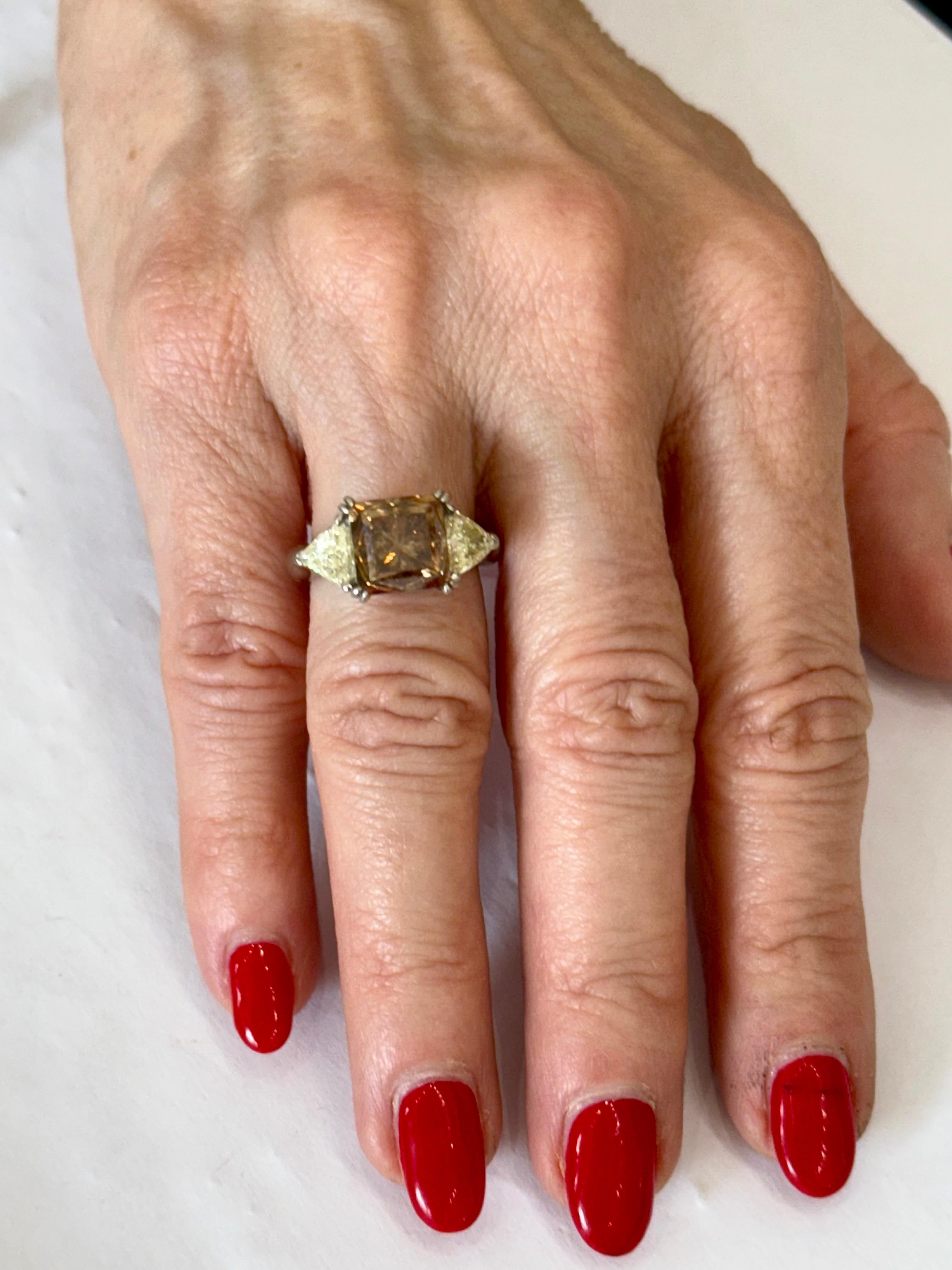 A stunning contemporary 6.123 carat diamond and platinum three stone engagement r
Ring; part of our diverse diamond jewelry and estate jewelry collections.
This fancy brown Princess cut diamond engagement ring is stunning from every angle. The