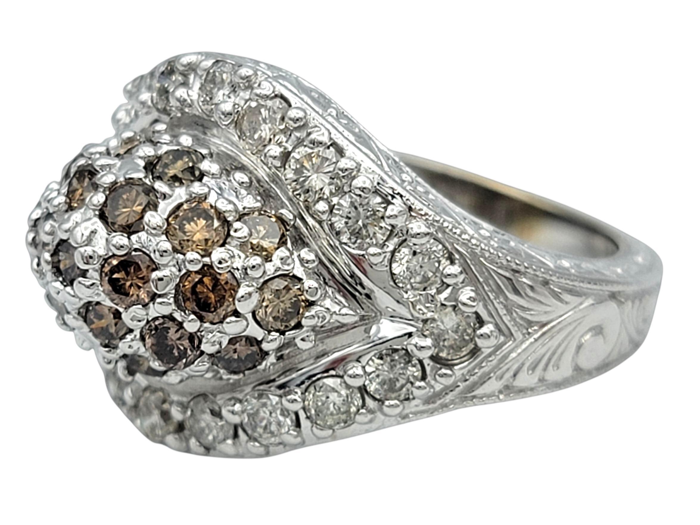 This shimmering diamond ring showcases a dramatic domed silhouette with a mesmerizing pavé surface that glimmers from every angle. At the center, warm-toned fancy brown diamonds create a rich focal point, surrounded by layers of bright white