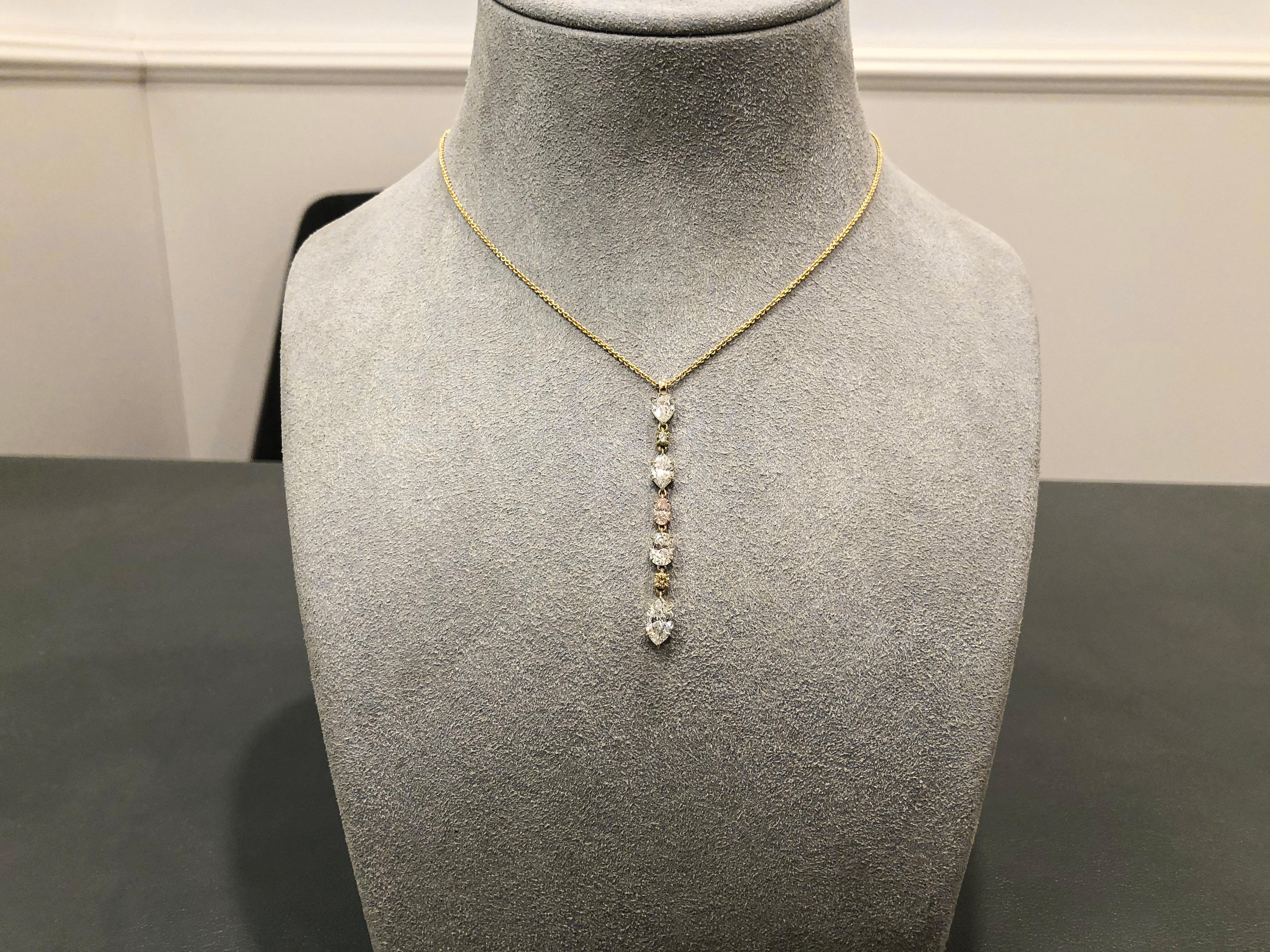 This is an incredibly gorgeous and colorful necklace showcasing different or fancy shaped diamonds set in an elegant drop. Each white diamond is spaced by either pink or yellow diamonds. Each diamond is set in an 18 karat yellow gold basket. White