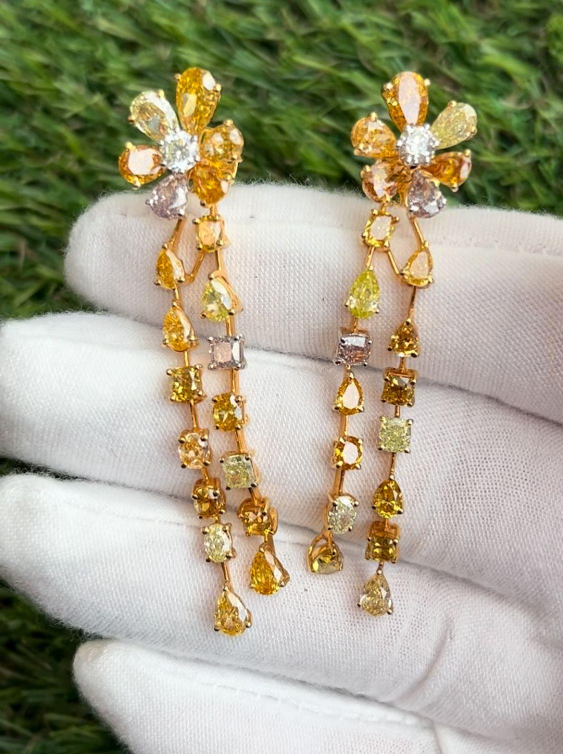 These one-of-a-kind natural fancy color diamond earrings are dripping in elegance.

14.27 Carats Total of Orange, Yellow, Pink, Green fancy color diamonds in a variety of shapes.

The earrings contain a total of 42 natural fancy color diamonds & an