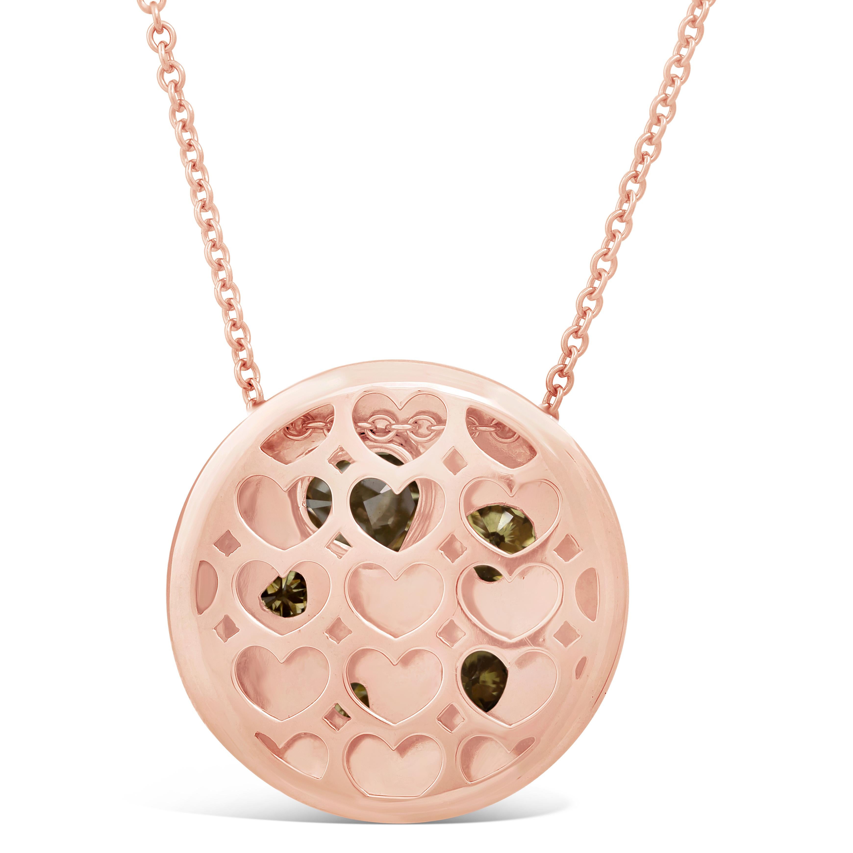 Features 5 colorful heart shape diamonds that vary in sizes set in an 18K Rose Gold bezel. Diamonds weigh 2.34 carats total. Accenting the heart shaped diamonds are vibrant round pink diamonds pave set in a circular pendant composition. Pink