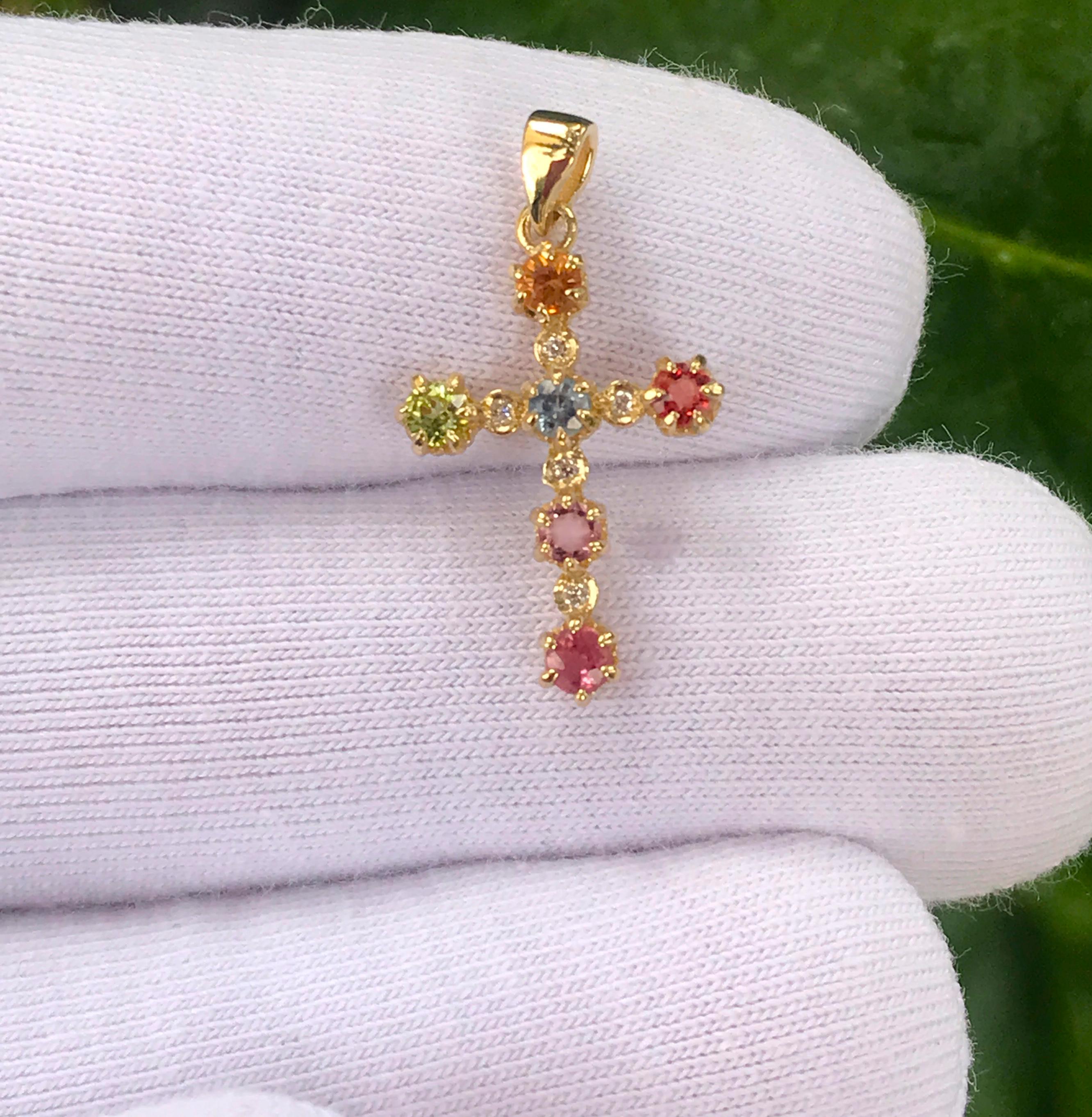  Cross pendant with fancy color sapphires and diamonds
Weight: 1.2 g.
Gold - 14k yellow gold 
Size -  22x12.5mm
Stones:
1. Fancy color sapphires 6 pieces - round cut, green, pink, red, light blue, yellow and purple color, transparent, 0.10x6 =0.60
