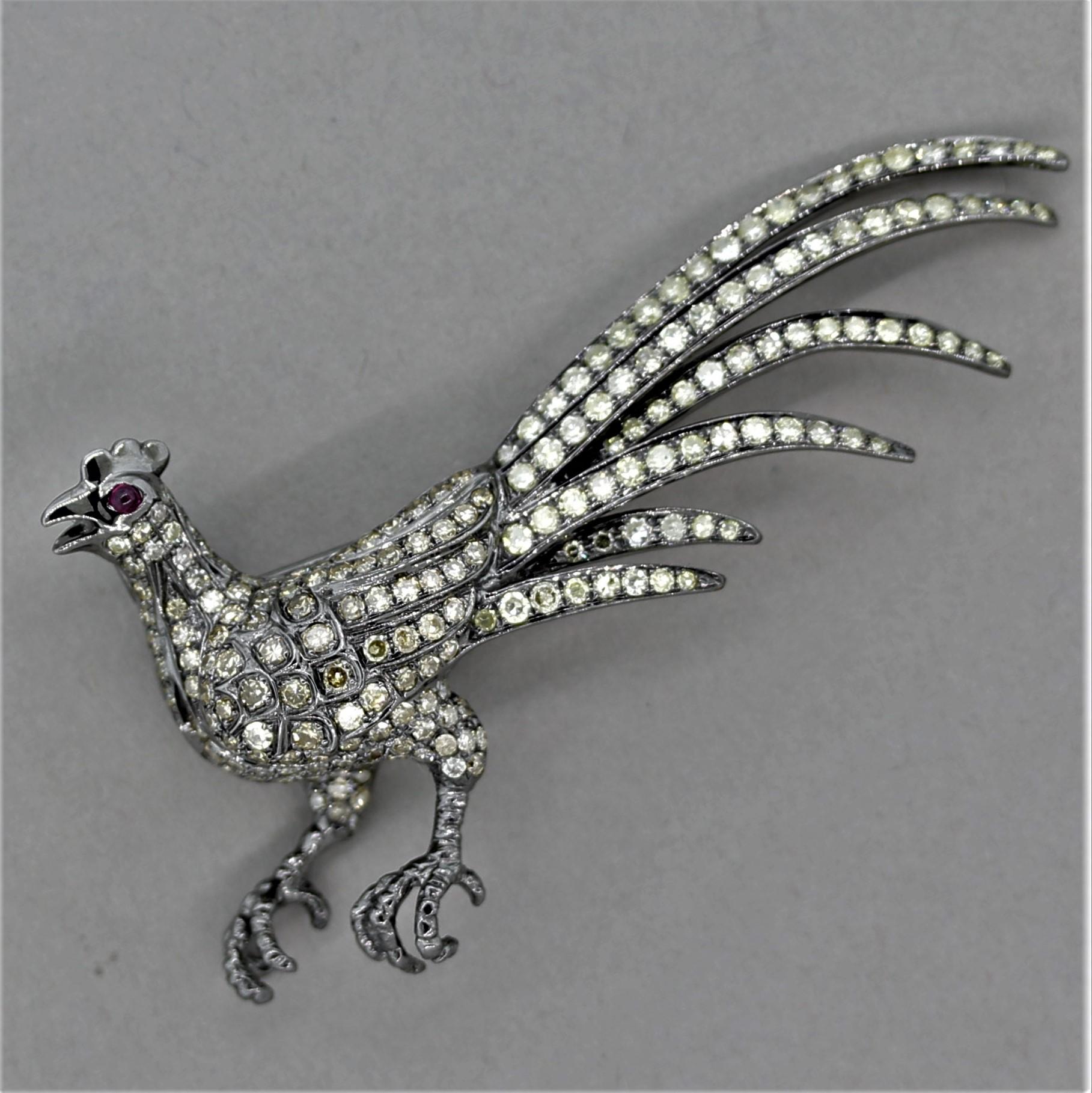 A proud and beautiful rooster! It features 3.23 carats of fancy-colored diamonds, which include yellows and cognac colors. Its mesmerizing eye is made of a single cabochon ruby. The piece is made in 18k gold with a rhodium finish giving the piece a