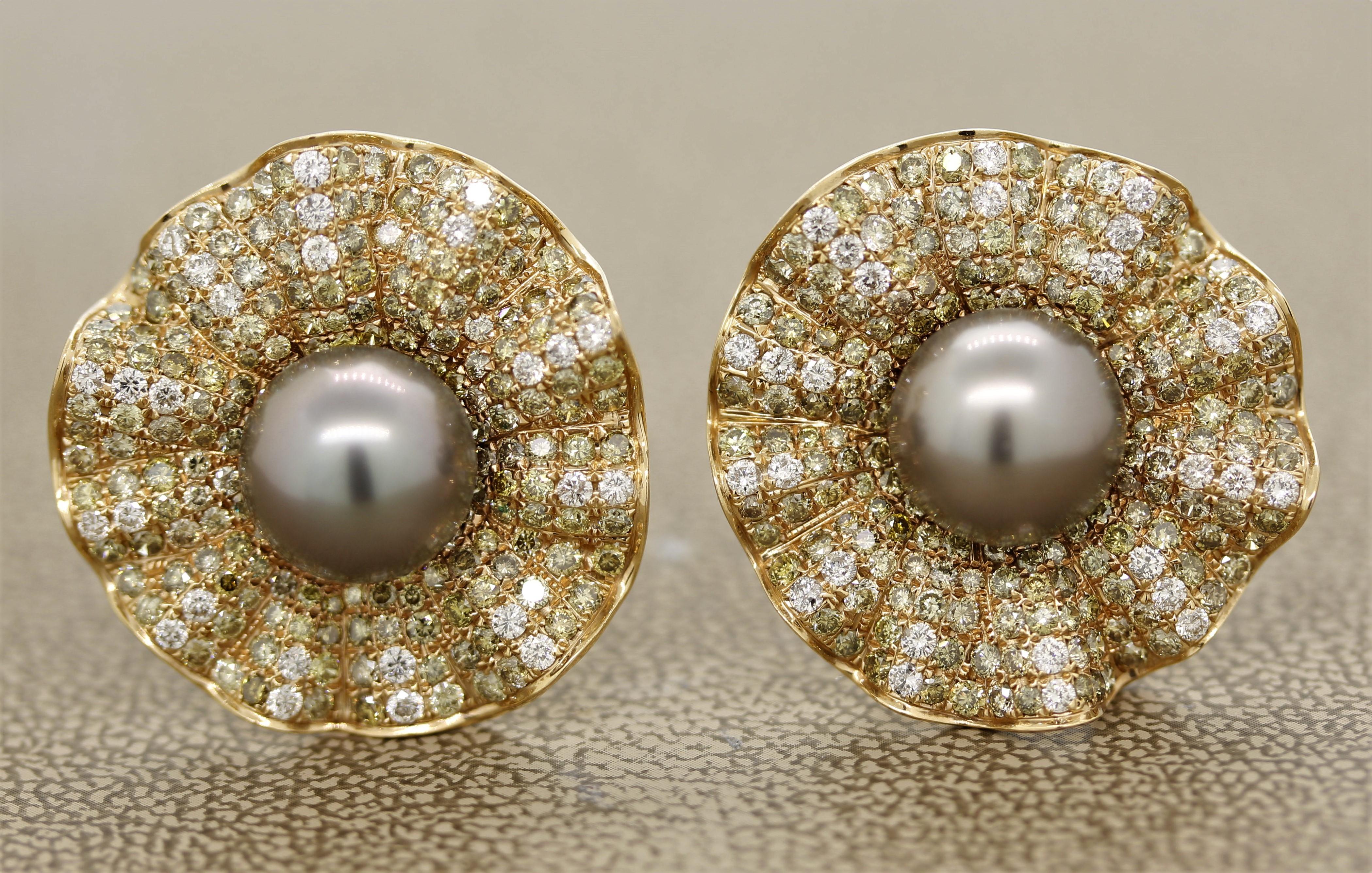 A stylish pair of earrings in a floral design. They feature 5.14 carats of white and fancy colored diamonds which adds contrast between their colors. In the center of each earring is a 10mm round Tahitian pearl with great luster and shine. Made in