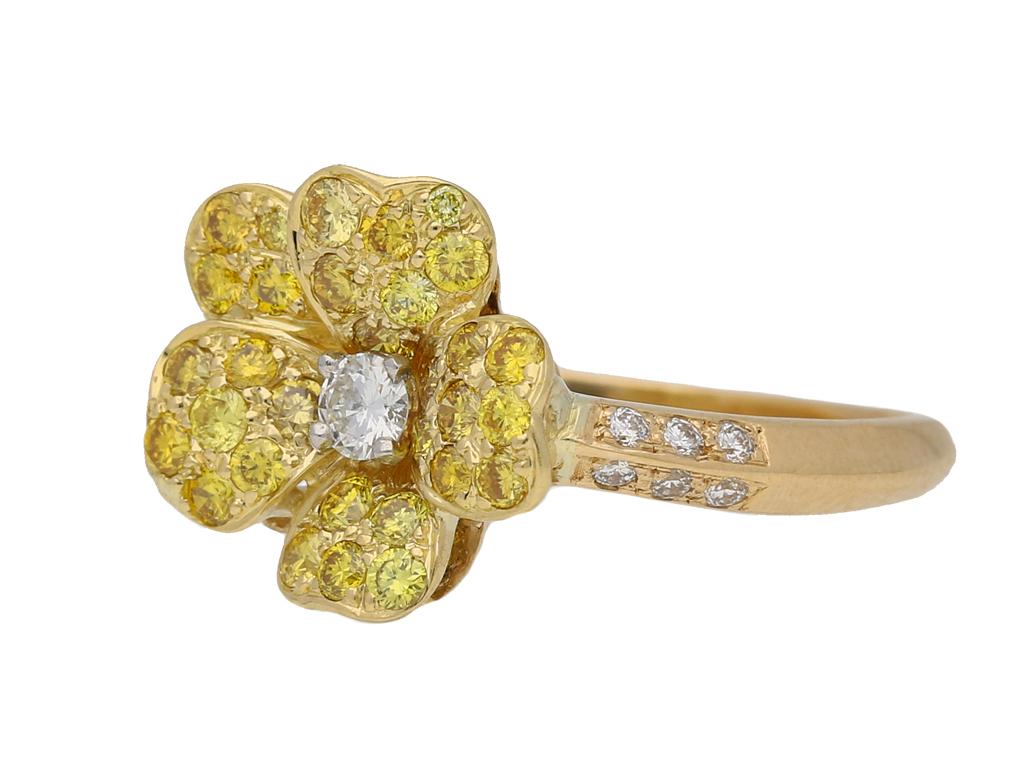 Fancy colour diamond flower ring by Oscar Heyman Bros. Set with thirty one round brilliant cut natural unenhanced yellow diamonds in open back grain settings with a combined approximate weight of 0.27 carats and further enhanced by thirteen round
