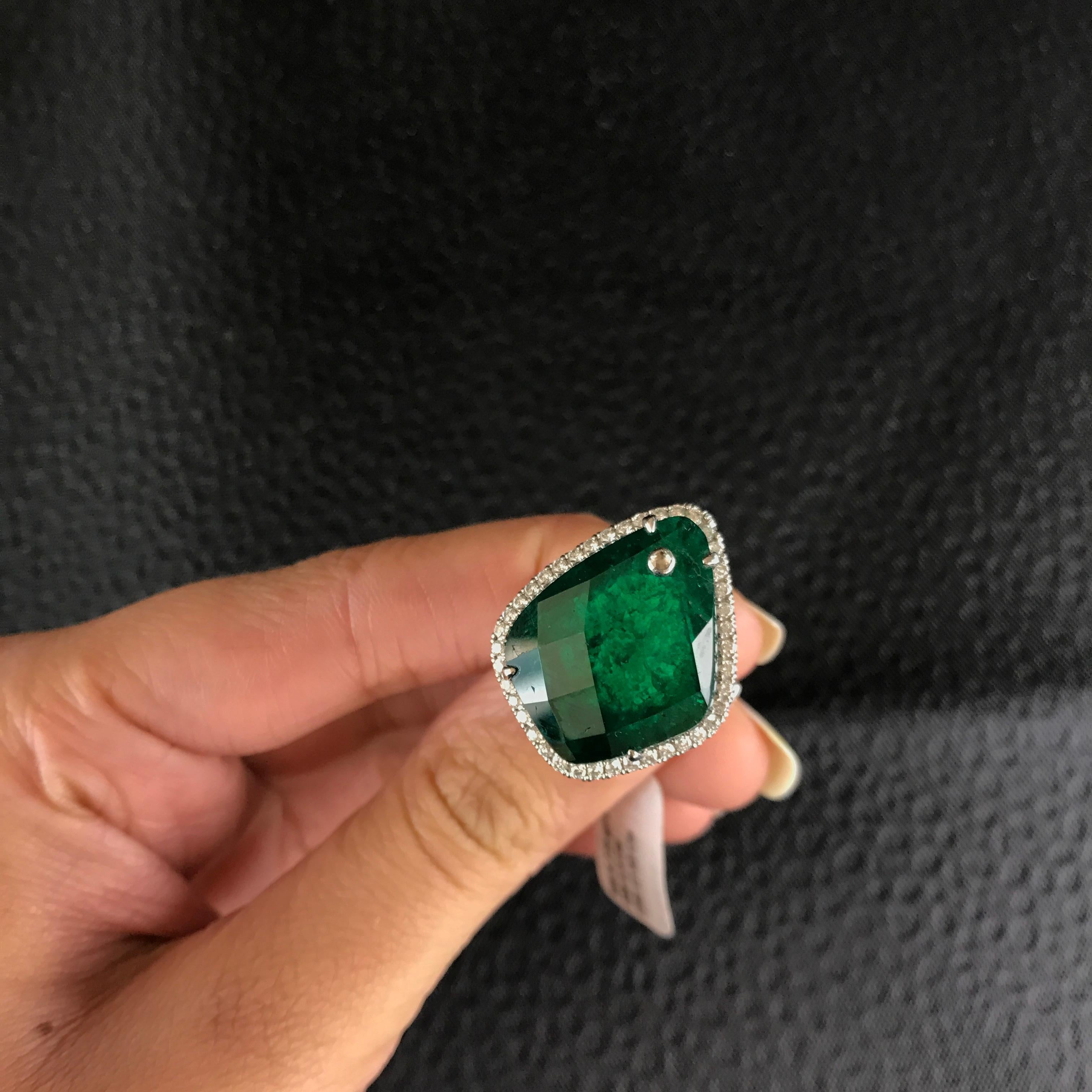 A Unique Fancy Cut Colombian Emerald and Diamond Cocktail Ring on 18K White Gold band

Center Stone Details:  
Stone: Colombian Emerald
Cut: Oval Weight: 22.43 carat

Diamond Details:
Cut: Brilliant (round) 
Total Carat Weight: 1.32 carat 
Quality: