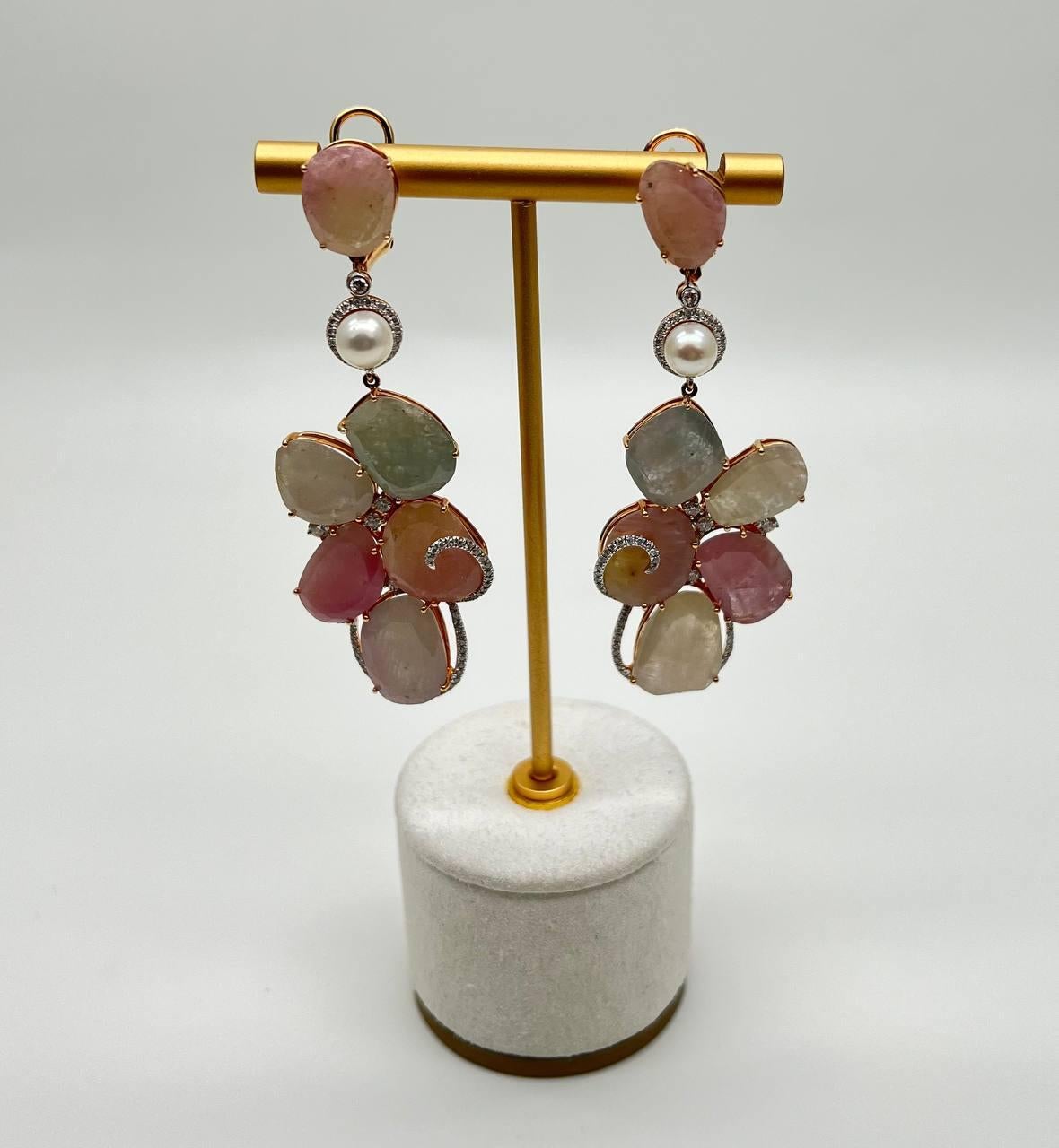Enhance your elegance with these stunning earrings crafted in solid 18 Karat rose gold.

Featuring a cluster of pastel-hued sapphire slices (76.8 CTW) , each piece is uniquely shaped, creating a harmonious blend of colors. The stones are set in a