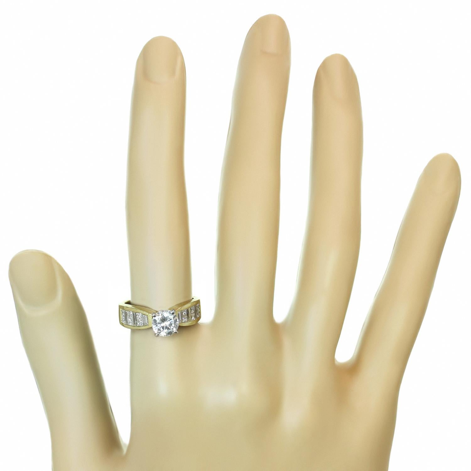 This gorgeous engagement ring is crafted in 18k yellow gold and features a cubic zirconium centerstone accented with fancy-cut diamonds on the band. The G-H VVS2-VS1 diamonds weigh an estimated 1.0 carats. Made in United States circa 1980s.