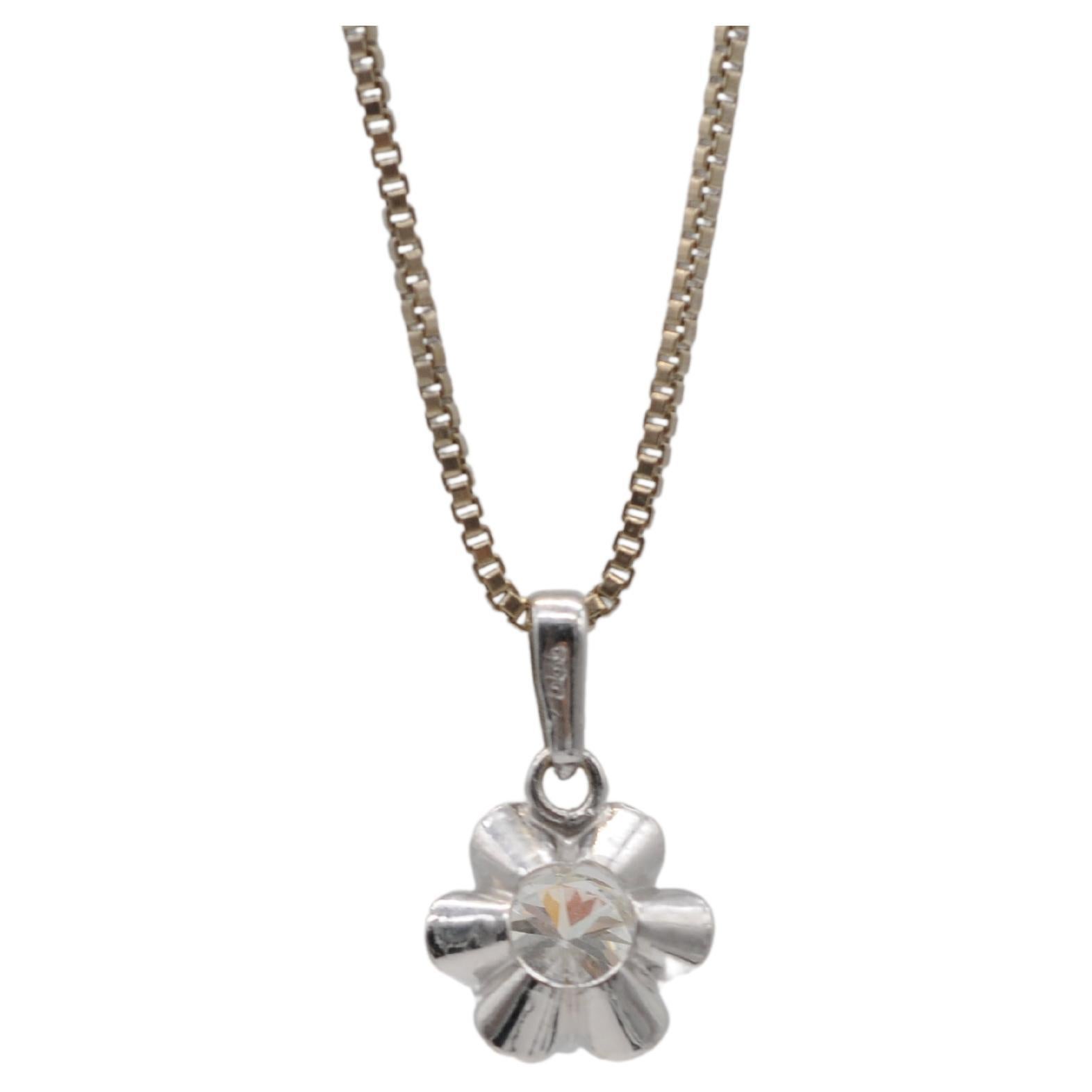 Embark on a journey of refined beauty with this exquisite 14k white gold necklace, a true testament to sophistication and elegance. The centerpiece of this captivating necklace is a beautiful flower-shaped pendant, cradling a precious treasure