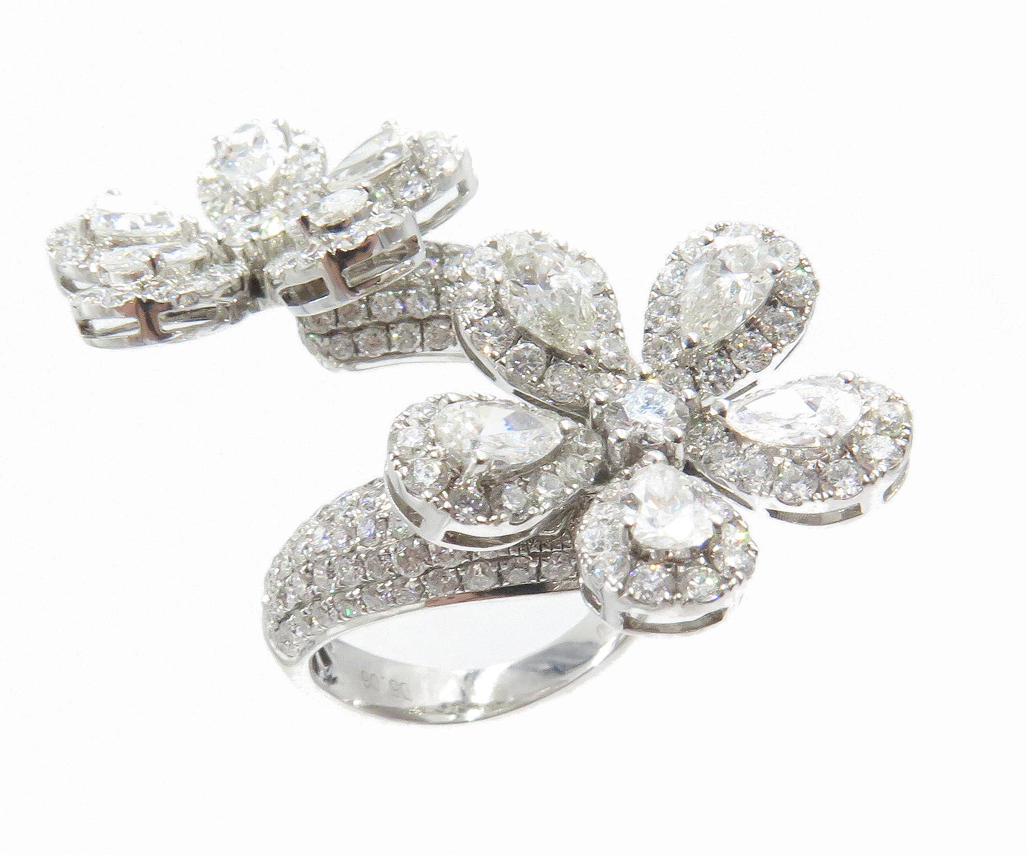  L'harmonie lustrée de l'or blanc 18k et des diamants est mise en valeur dans cette bague à double fleur fantaisie magnifiquement fabriquée à la main. Ajoutez de l'éclat à vos doigts avec ces fleurs scintillantes, fleuries de 5,06 cts de diamants.