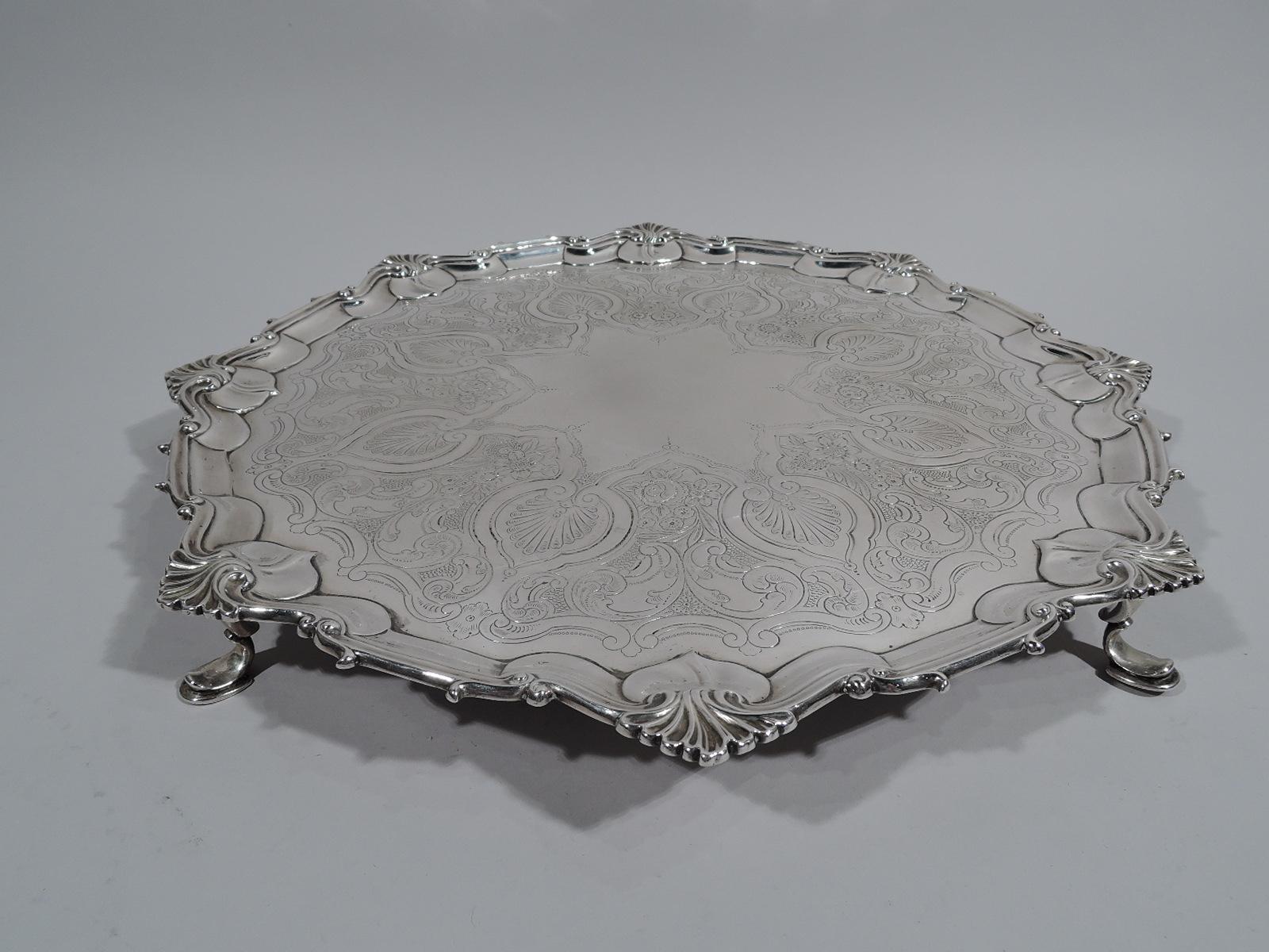 Victorian Georgian sterling silver salver. Made by William Hutton & Sons, Ltd in Sheffield in 1898. Round shaped well, engraved with dense ornament: Palmettes surrounded by scrollwork and flowers. Center has star cartouche (vacant). Molded