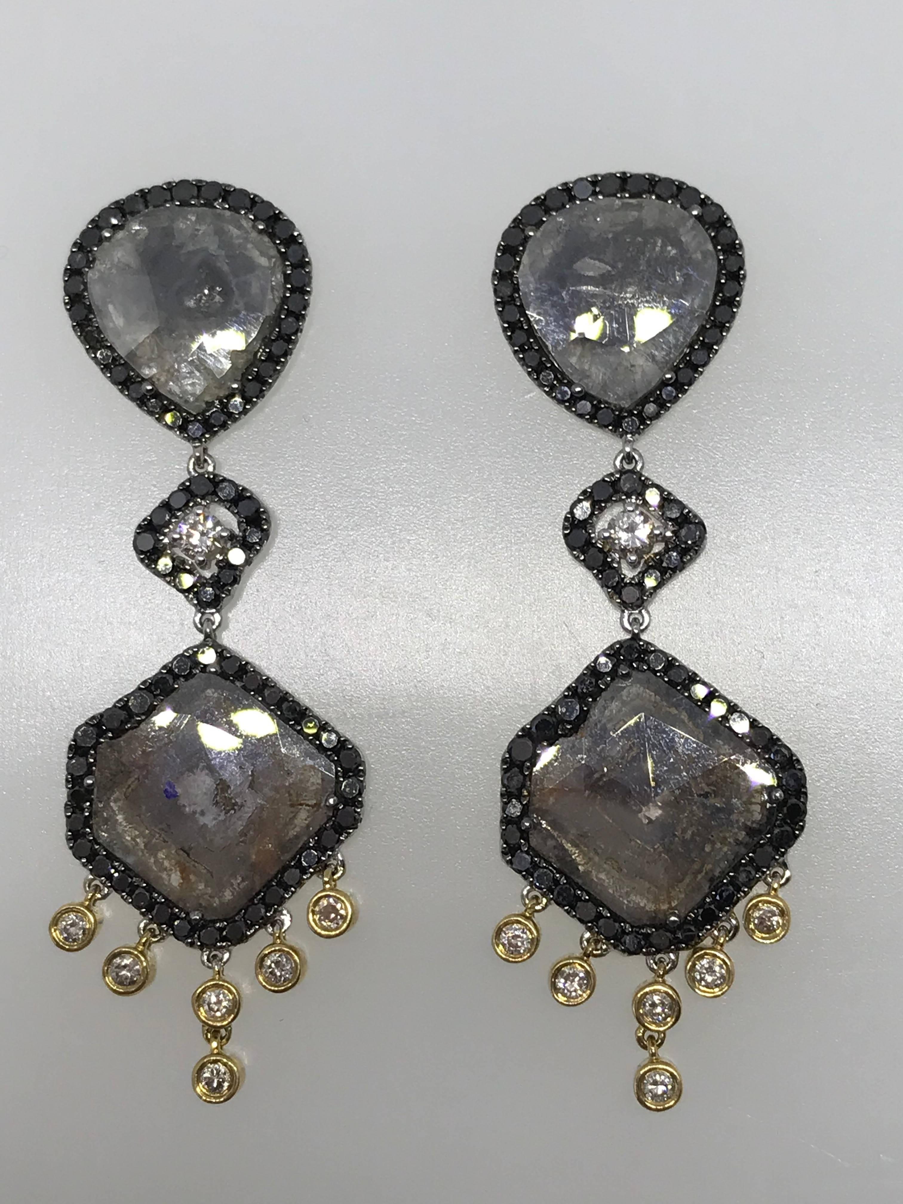 These Gorgeous earrings are studded with fancy flat diamonds and small black diamonds all around.
Details:
18k White and Yellow gold 7.65 grams tw.
4 Flat Diamonds 6.18 carats
2 Diamonds 0.12 carats, 12 Diamonds 0.19 carats
142 Black Diamonds 1.35