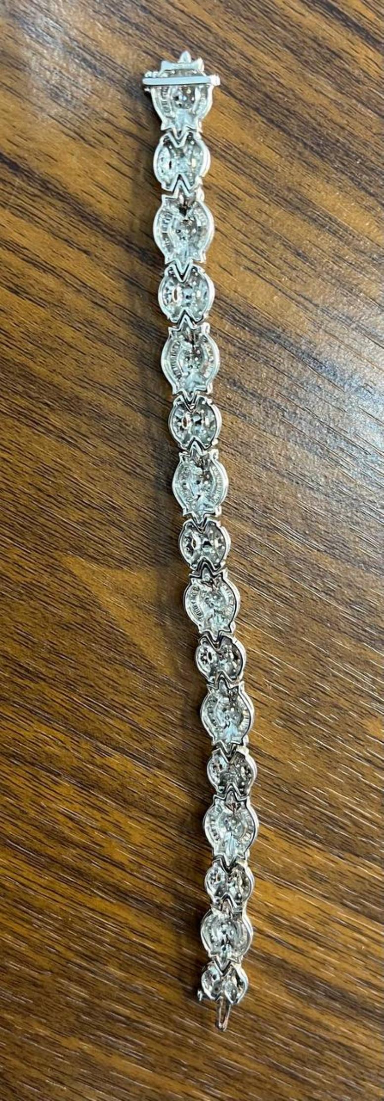 Elegamment confectionné, ce bracelet exquis présente une série de motifs floraux au dessin complexe, chacun orné de diamants scintillants qui captent magnifiquement la lumière. La pièce présente un motif continu de pétales qui se chevauchent, créant