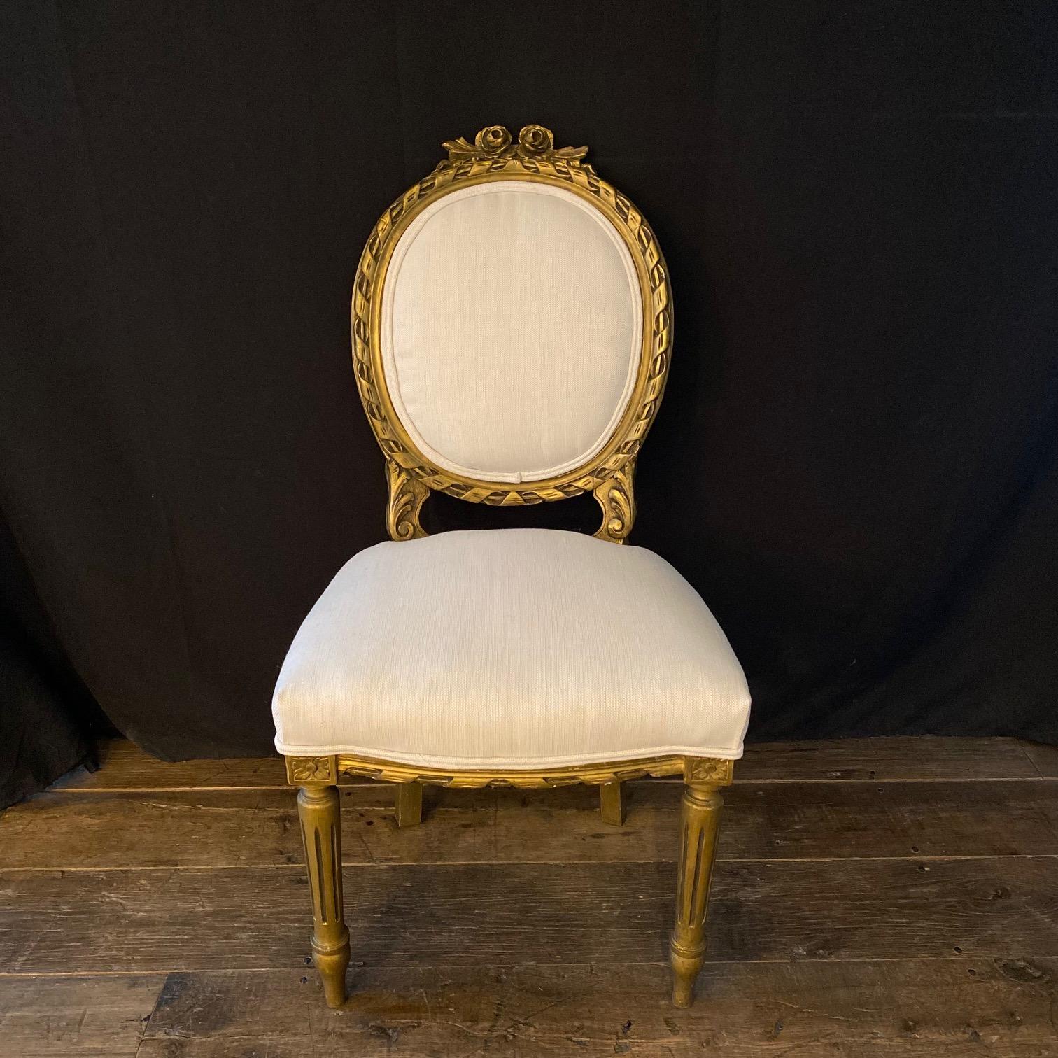 Moviestar glamorous pair of Louis XVI period carved giltwood side chairs. We love the restrained elegance of the Louis XVI style, and these chairs feature many of the details characteristic of the style--oval back, lovely carvings and tapered,