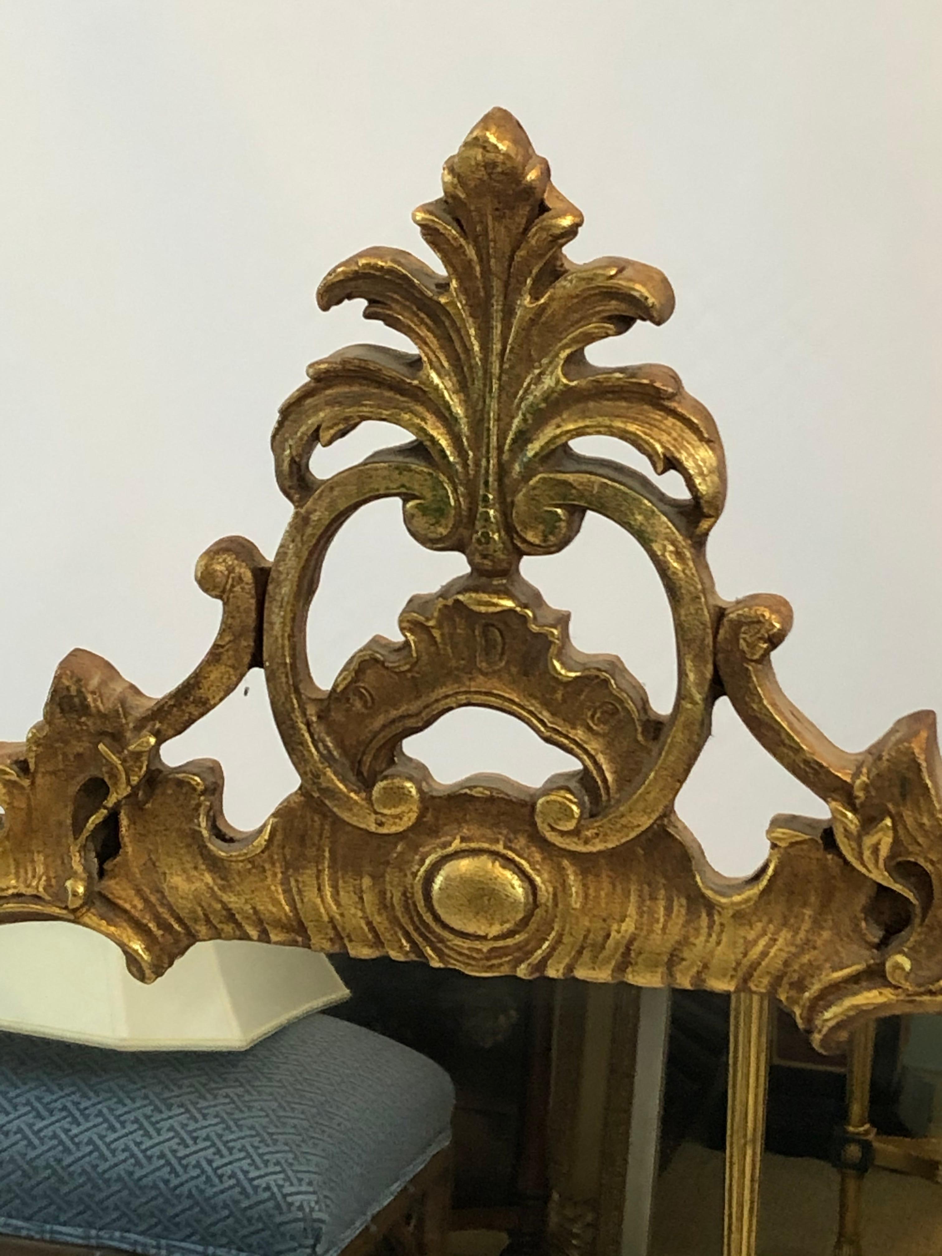 Ornate French Louis XVI style giltwood mirror with fancy leaf foliage.