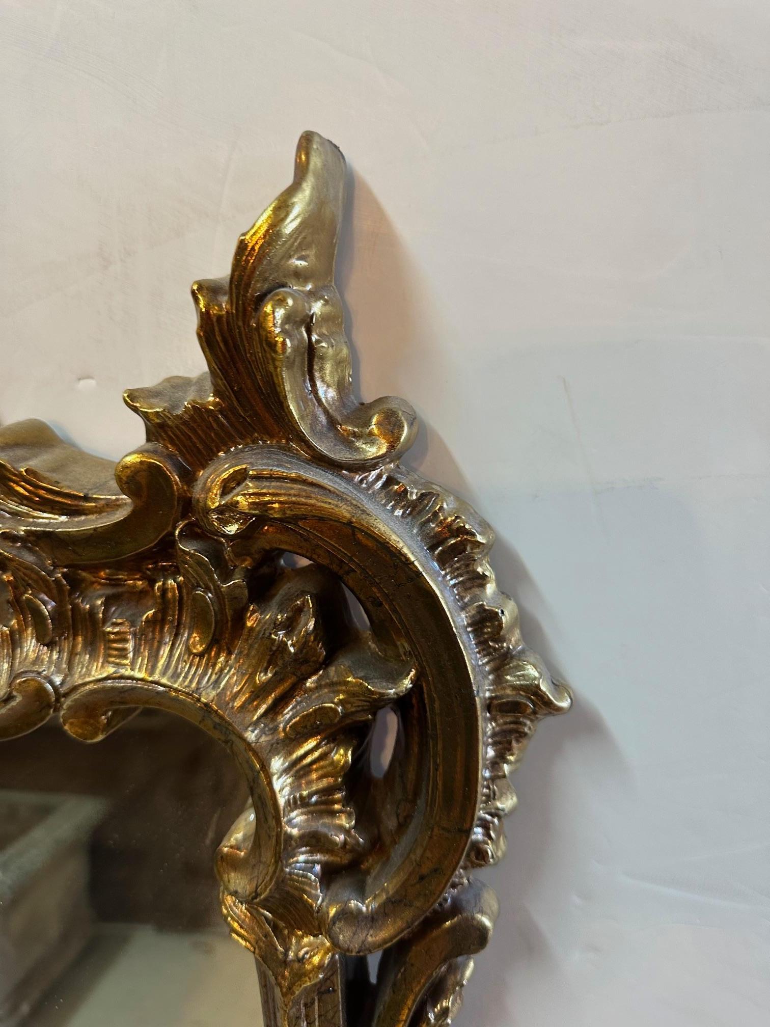Fancy Louis XVI style gilt composition mirror with swirls and curlicues.
