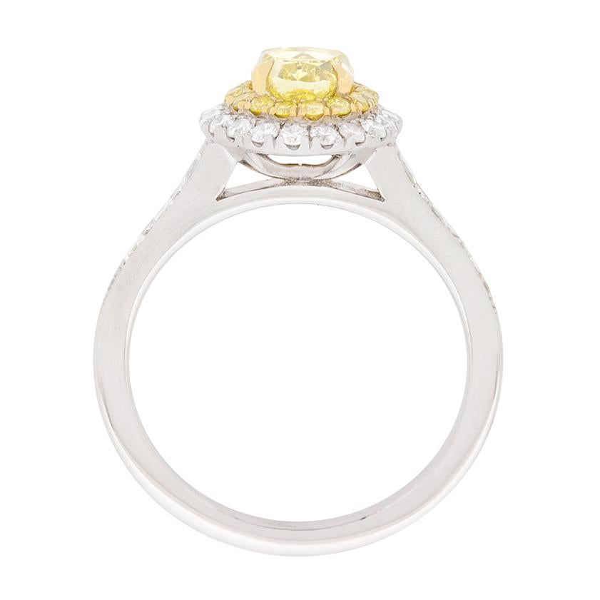 Bien que moderne, cette bague est  seconde main et présente un fabuleux diamant jaune en son centre. Elle a un certificat GIA, et est Fancy Intense Yellow, avec un degré de clarté de VS1. Elle est sertie de griffes et magnifiquement mise en valeur