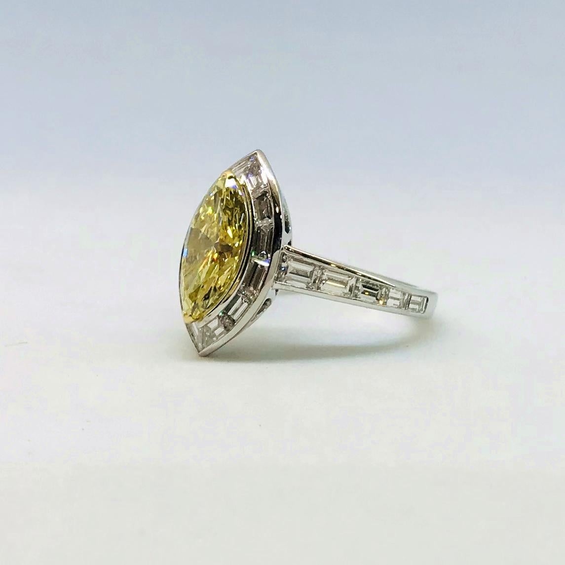 One Fancy Intense Yellow, GIA certified, marquise-cut diamond ring.  The platinum ring centers the marquise-cut diamond, weighing 2.21 cts with VS2 clarity, mounted with 2-“V”-shaped, 18 Karat yellow gold prongs which is then surrounded by a single