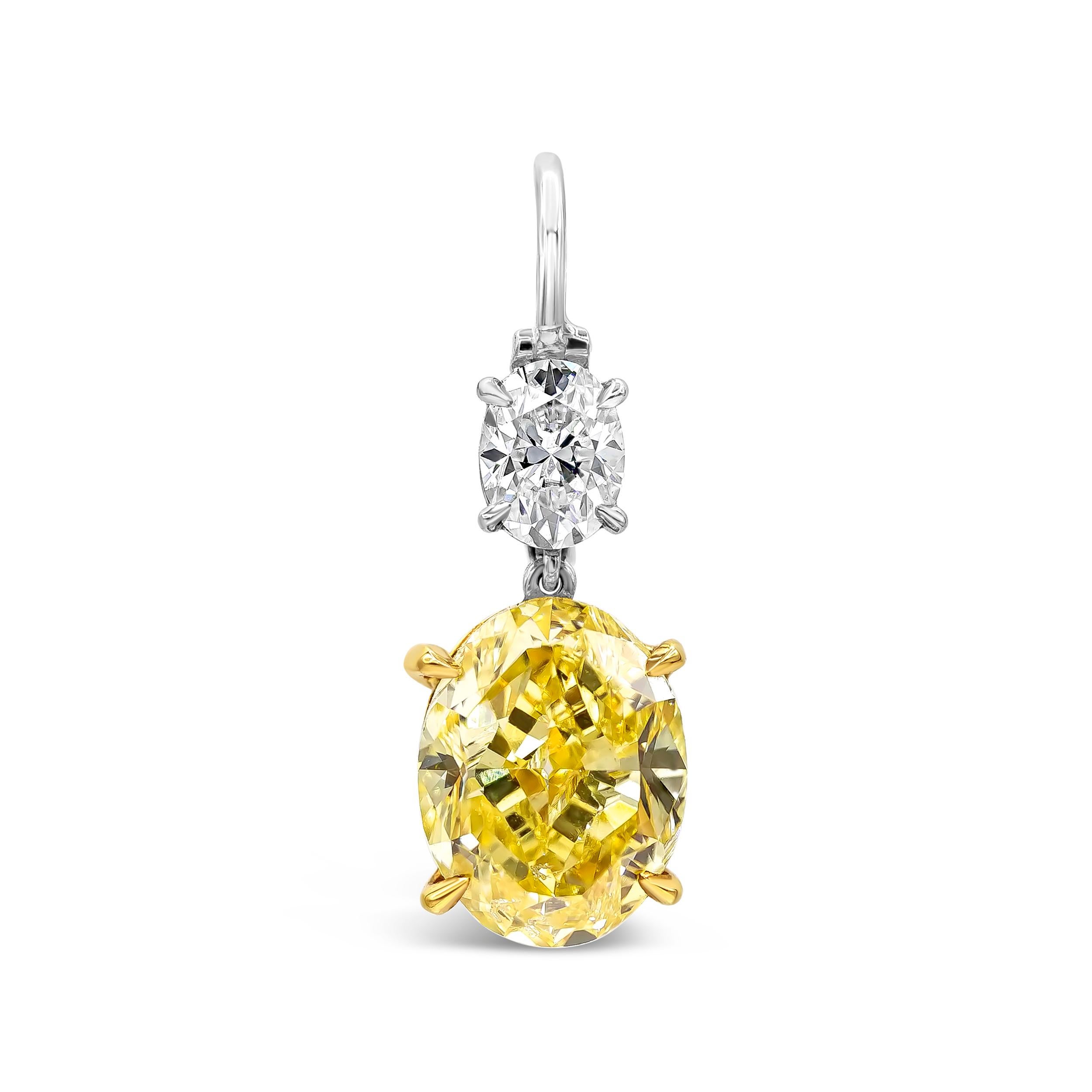 Color-rich drop earrings showcasing brilliant oval cut yellow diamonds weighing 3.21 and 3.07 carats respectively. Each yellow diamond certified by GIA as Fancy Intense Yellow color, SI1-SI2 clarity. Accenting the yellow diamond is a smaller oval