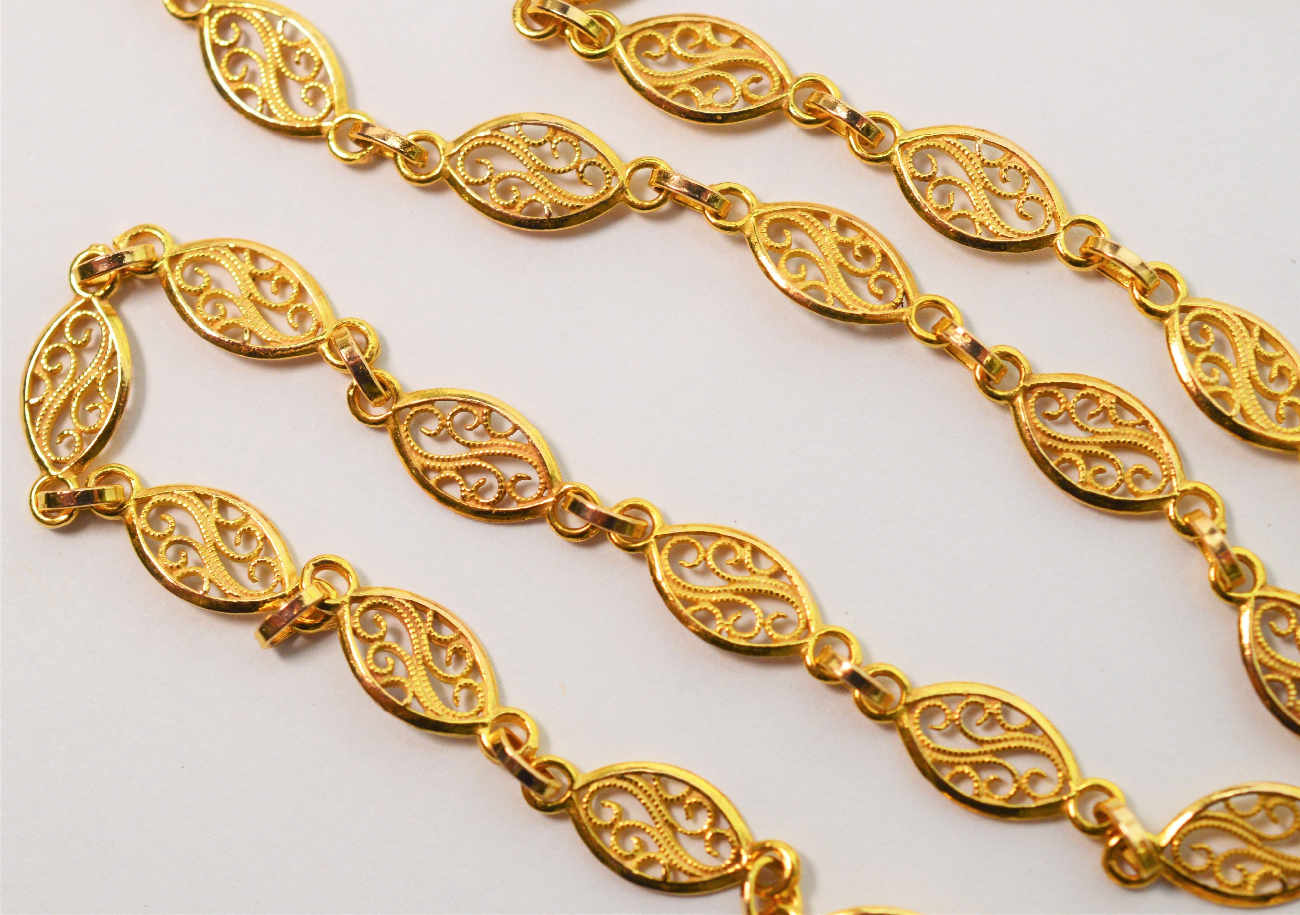 Italian made and in bright fourteen karat 14K yellow, this pretty fancy filigree flat link chain is 24 inches in length and finished with a lobster clasp. The width of the oval links are approximately 5mm. Gift Boxed.