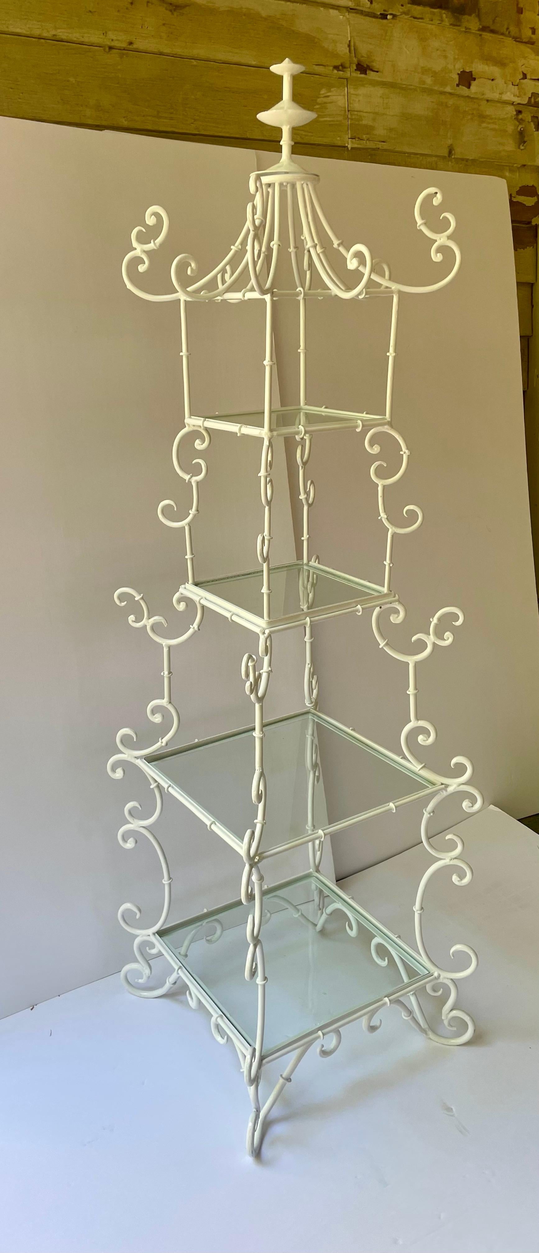 Etagere italiana a forma di pagoda a quattro livelli, costruita in ferro battuto a forma di voluta con una recente finitura a polvere bianca. Caratterizzato da un terminale stilizzato e da splendidi dettagli a voluta con quattro ripiani in vetro. I