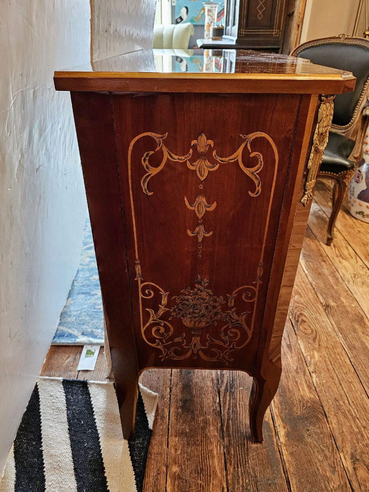 Elegant medium sized two drawer commode having magnificent glossy mahogany with curlicue paint and gilt decoration, shiny brasses and cabriole legs.  