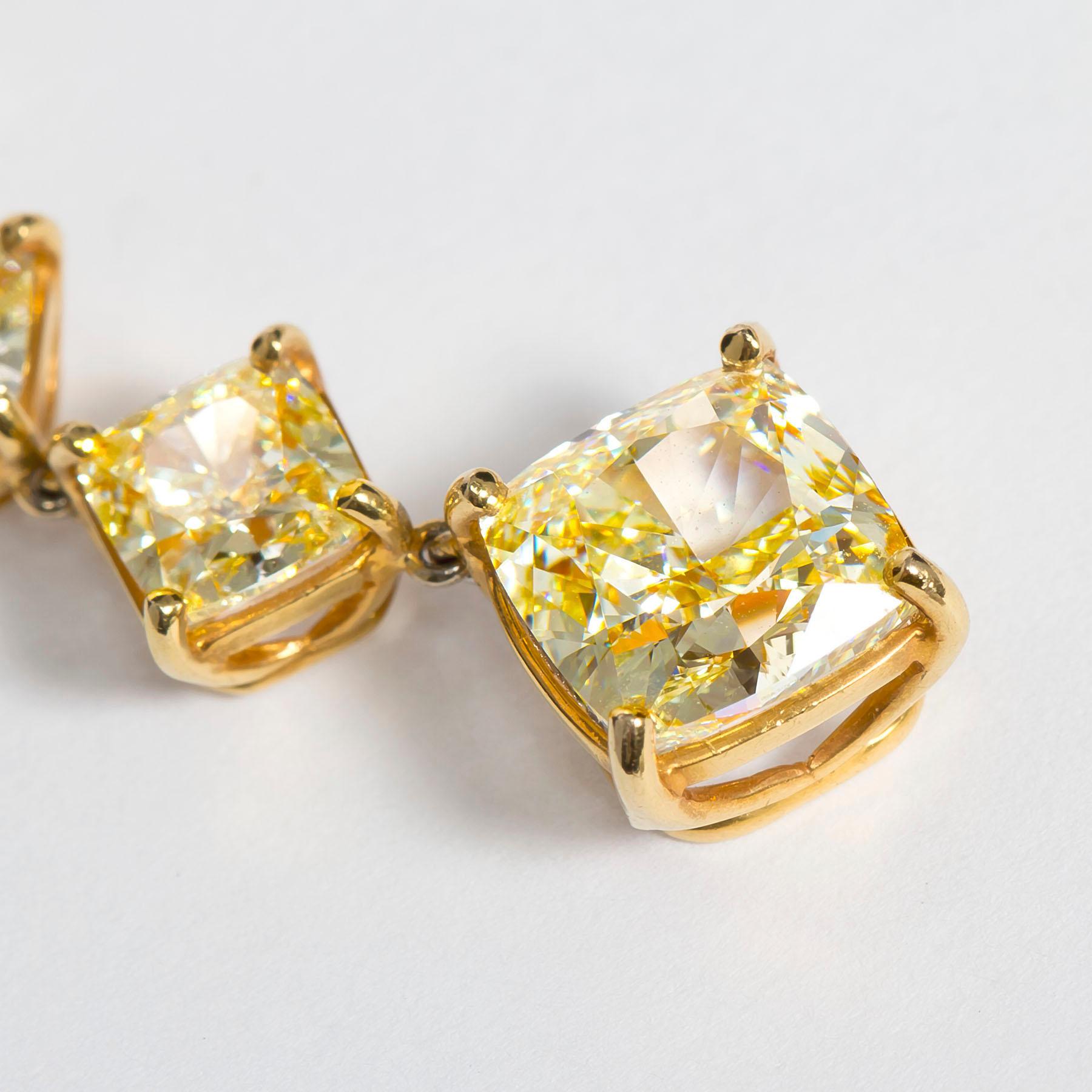 These 18 karat yellow gold Fancy Light Yellow Cushion Dangle Earrings with 16.50 total carats of diamonds are a showstopper! The choice of fancy light yellow diamonds, cushion cut, and the substantial total carat weight contribute to a piece that is